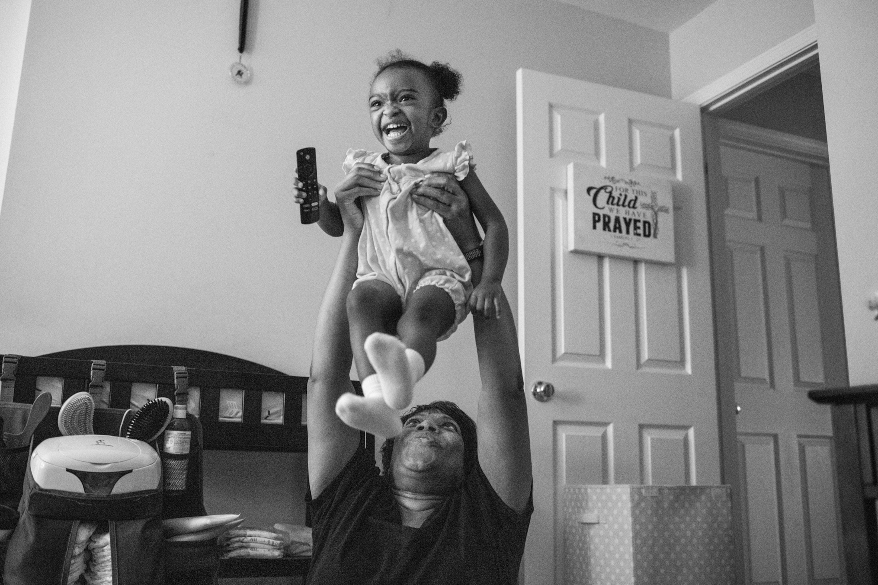 Woman holding a baby girl over her head.