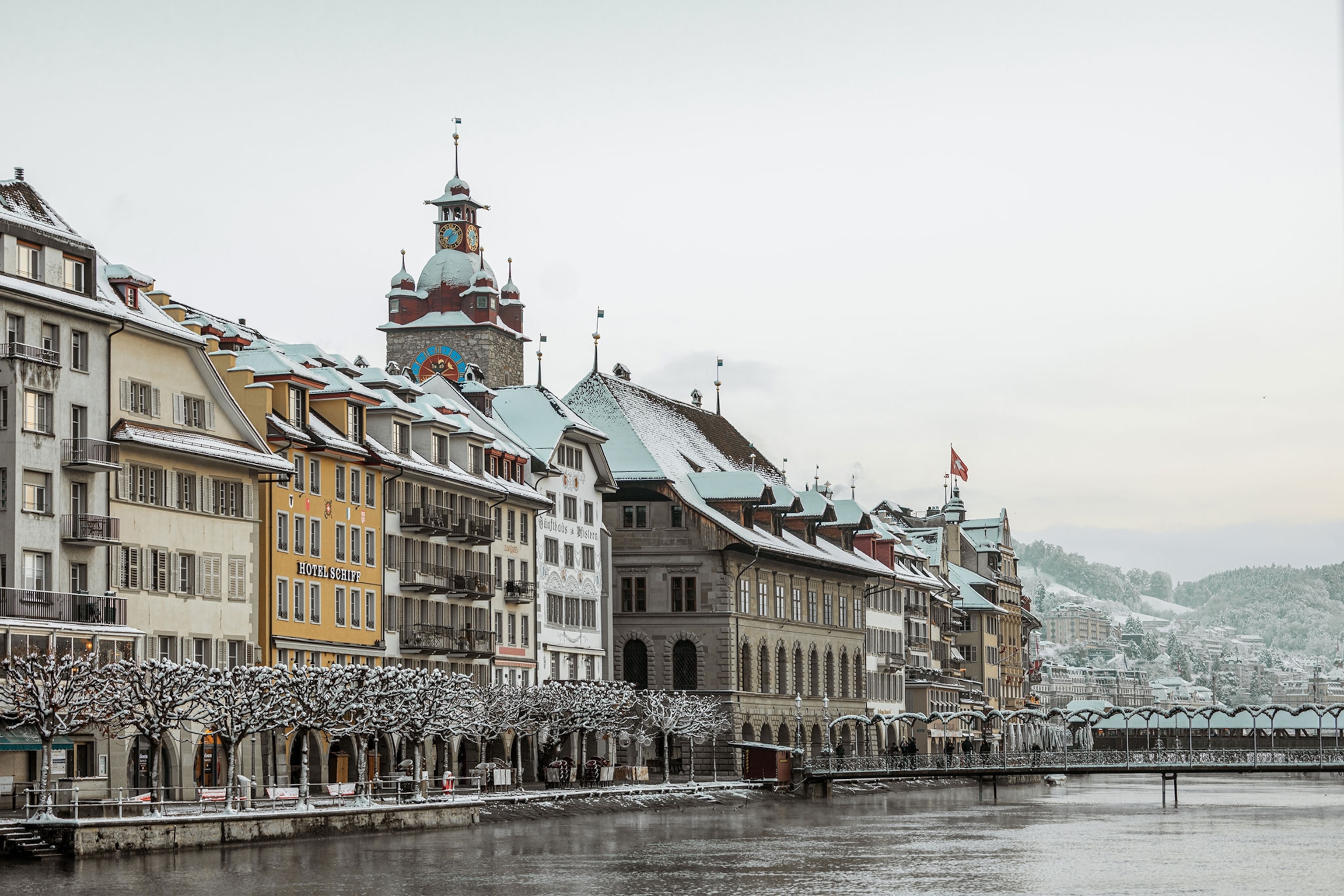 The colourful buildings of Lucerne are seen on the shores of the lake on a grey winter's day.