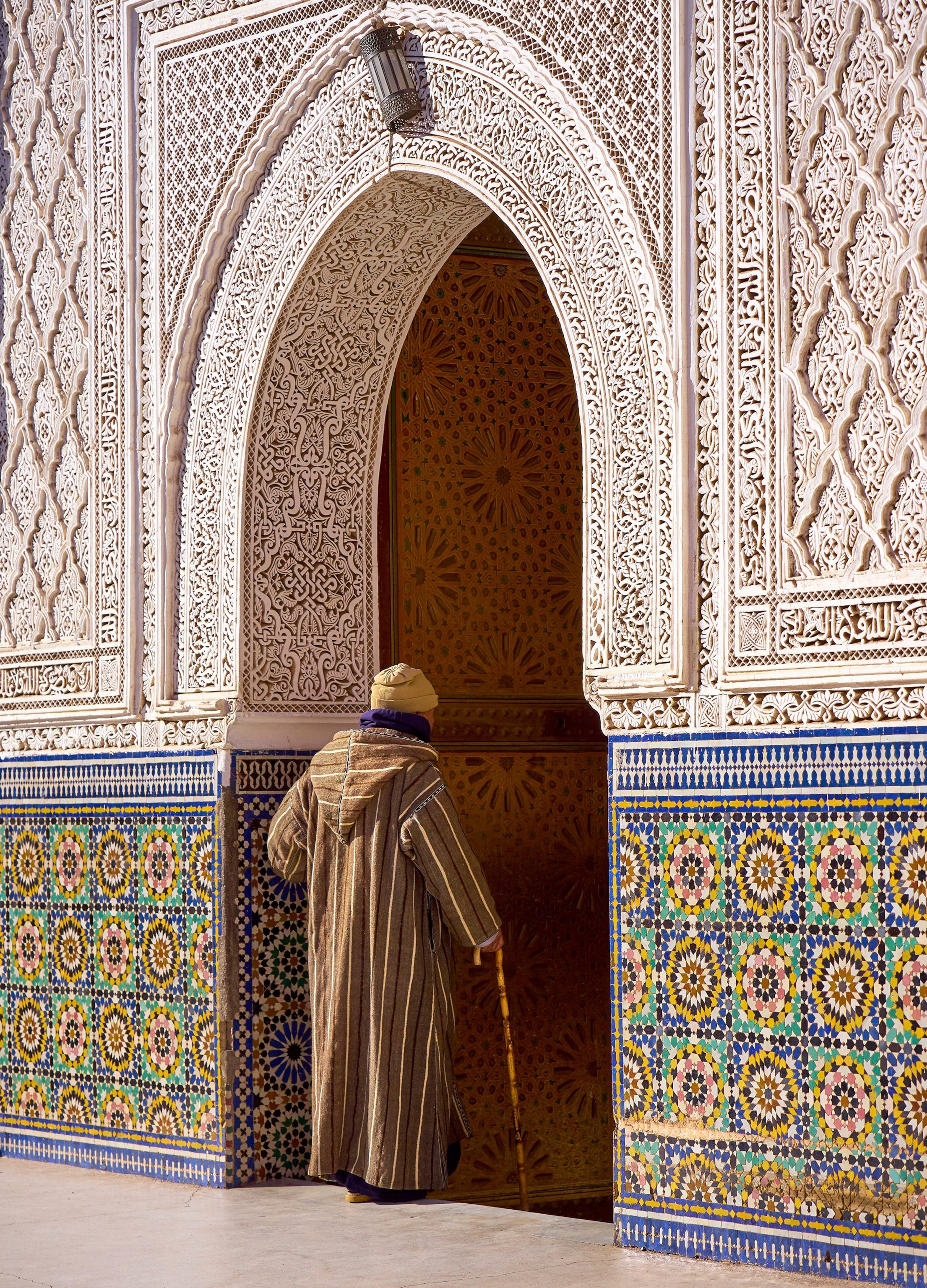 an elderly gentleman with a cane entering a mosque in Marrakech, Morocco