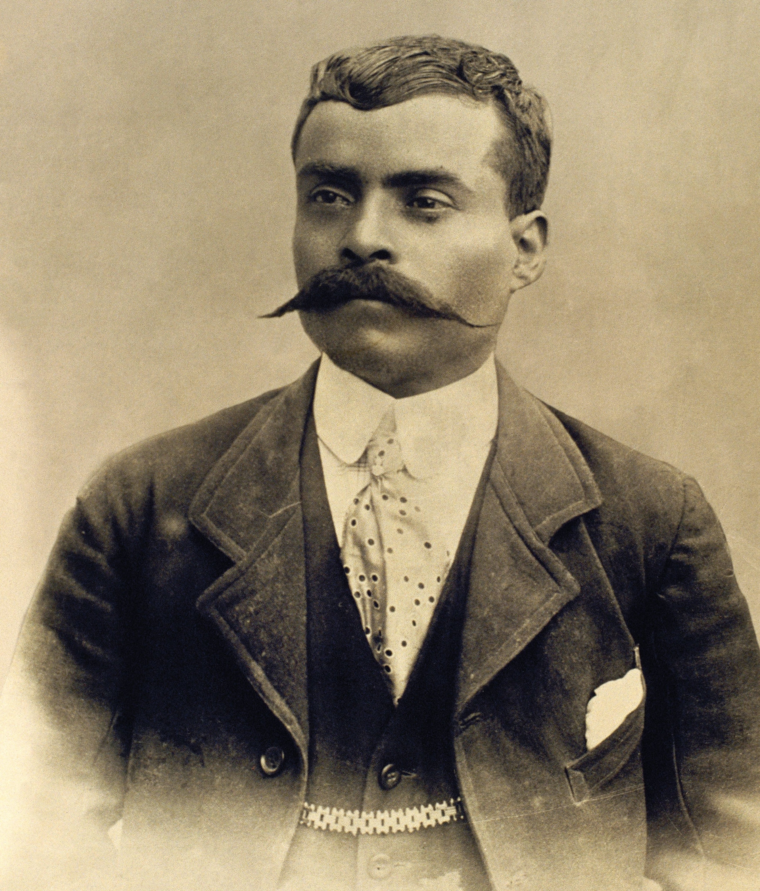 A portrait photo of Zapata with a mustache, and suit and tie on