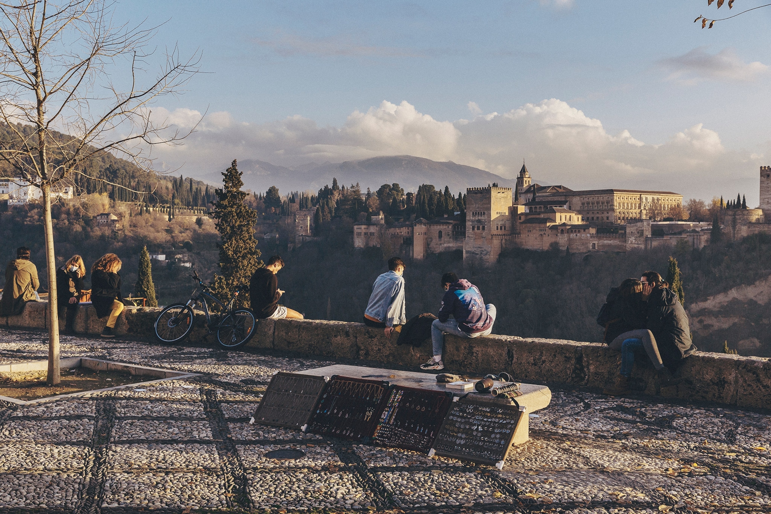 Tourists watch the sunset over the Alhambra Palace from the famous Mirador San Nicolas