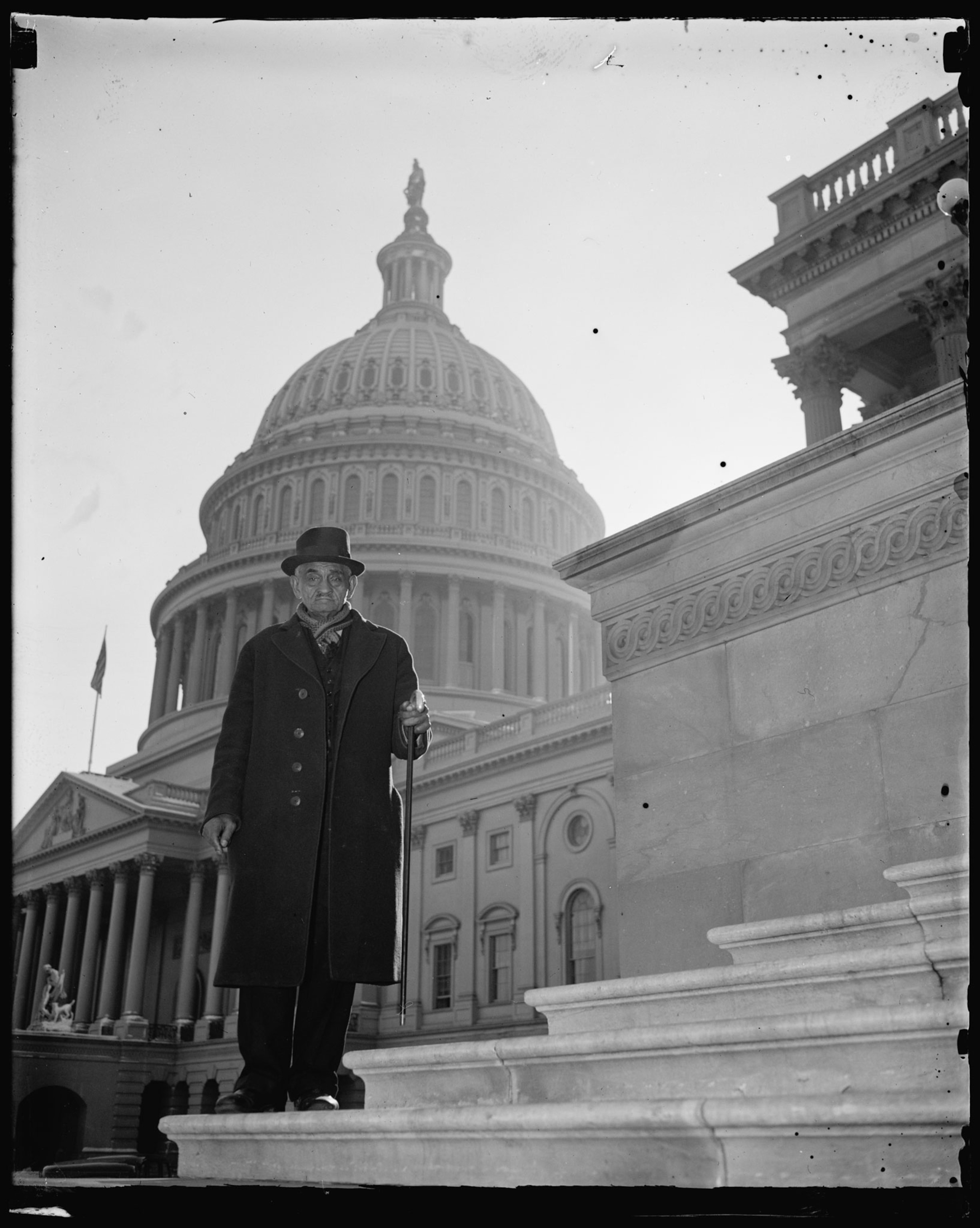 An African American man stands on the steps of the Capitol Building in DC