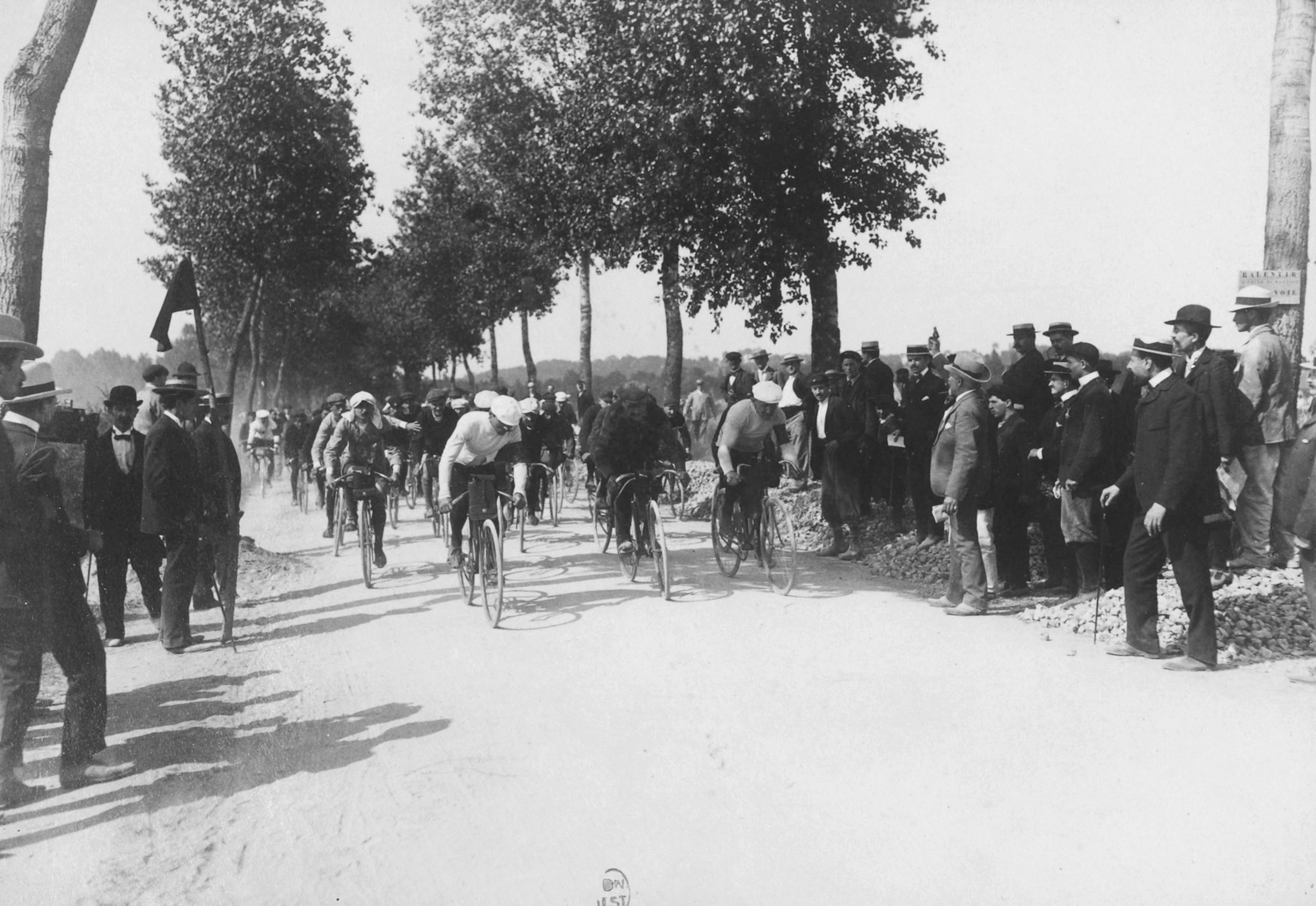 men riding bikes past a crowd