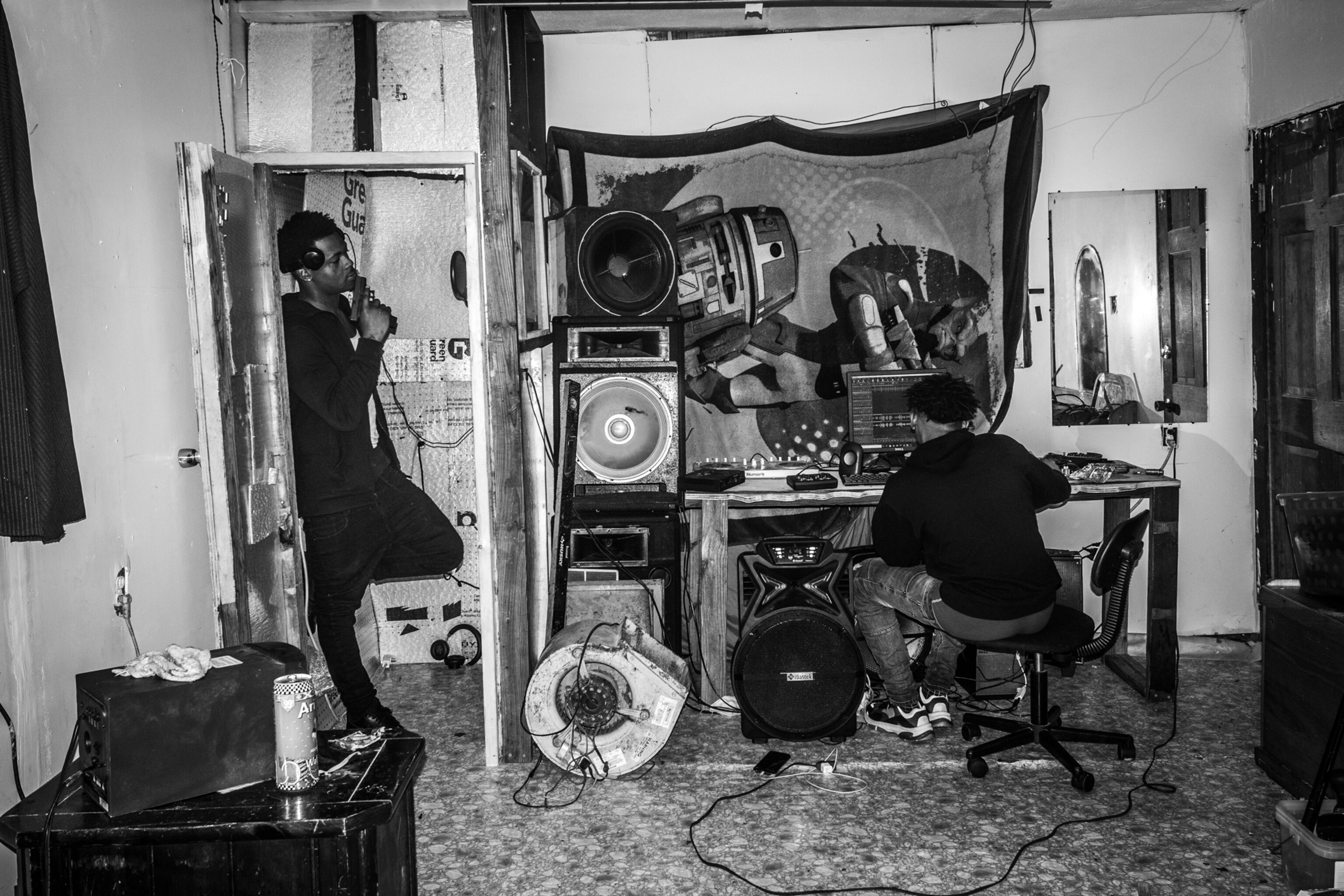 Two men record music in a home-made studio.