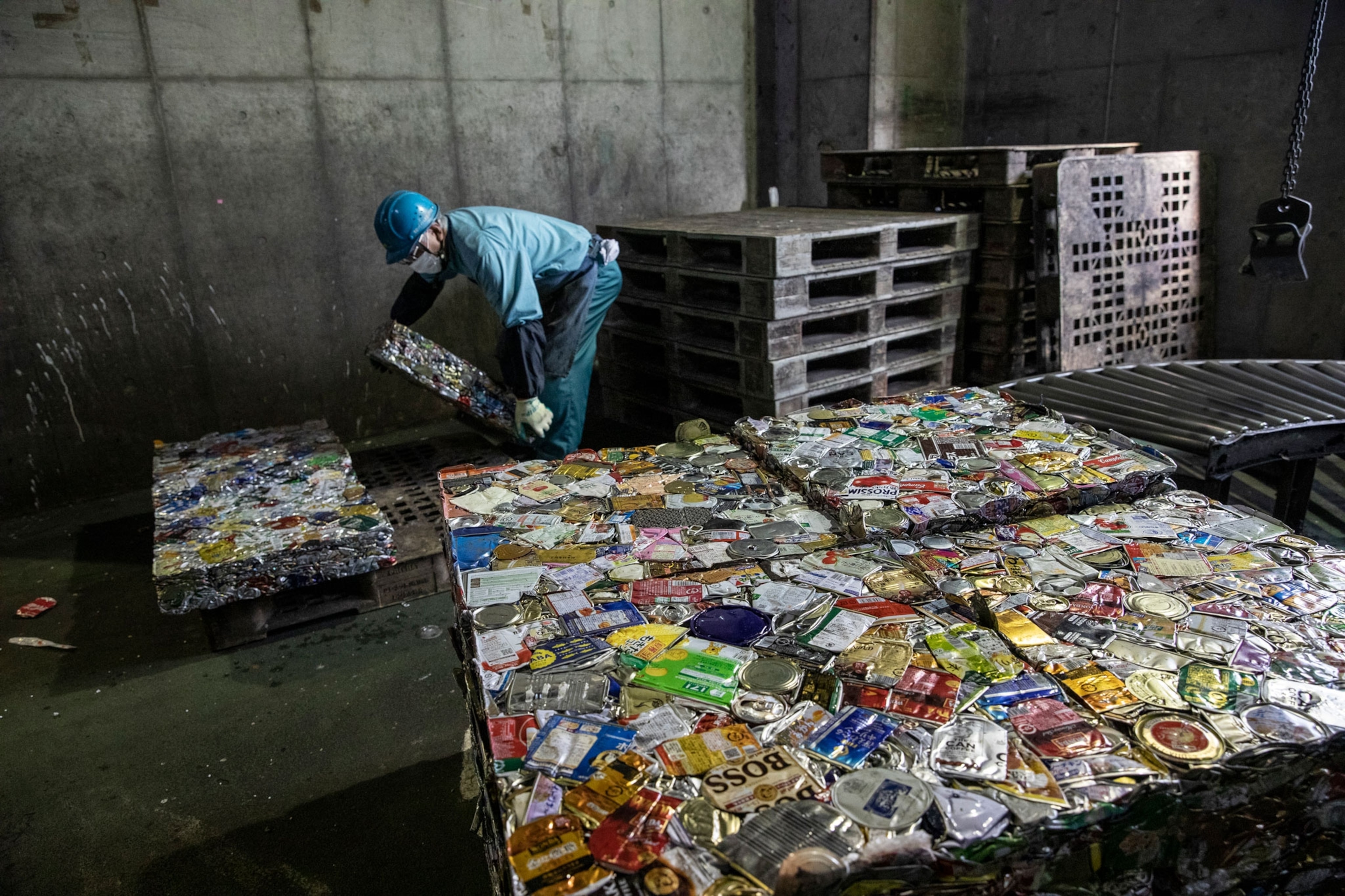 a man picks up a square of crushed metal