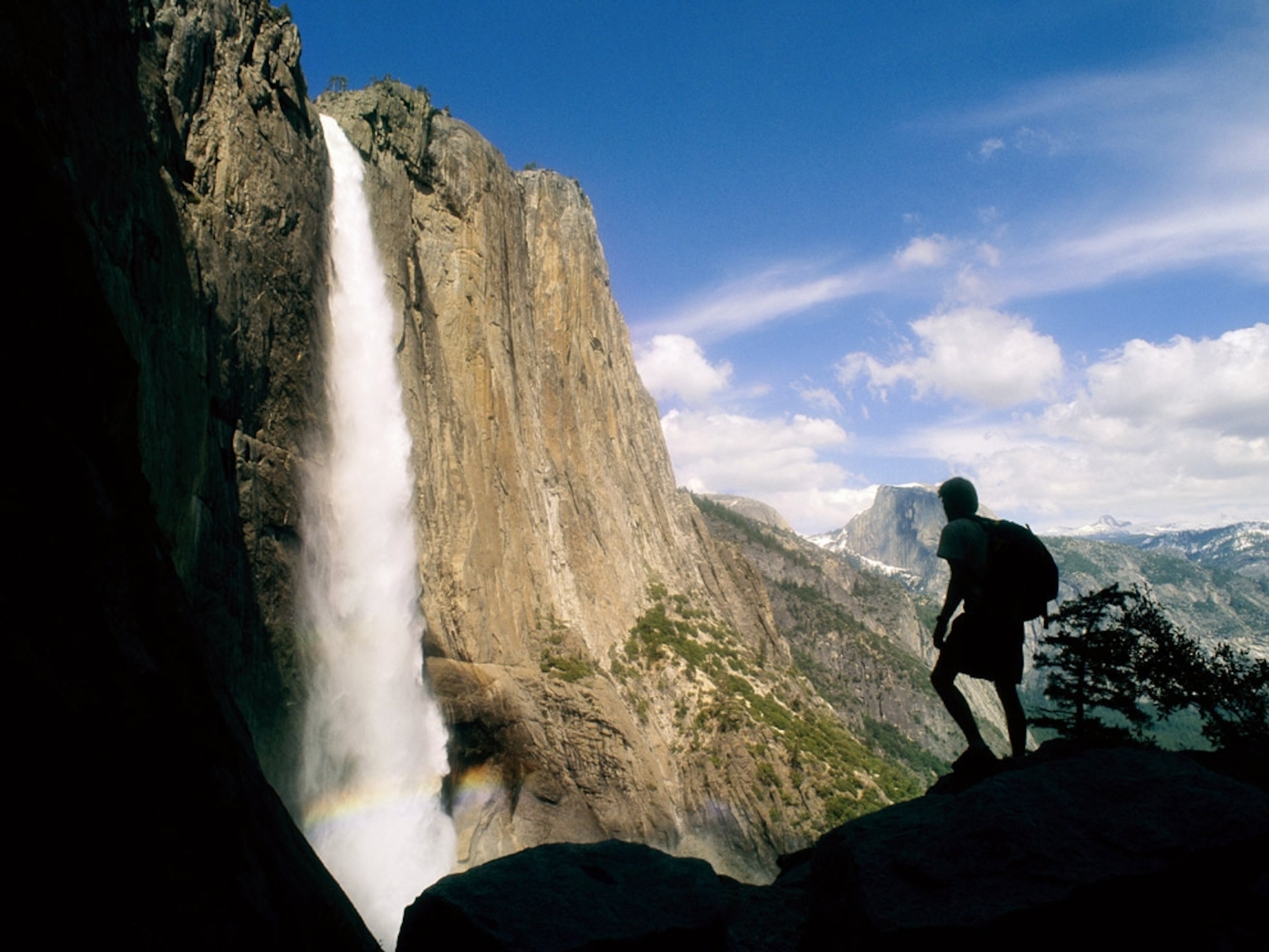 Hiker looks at large waterfall