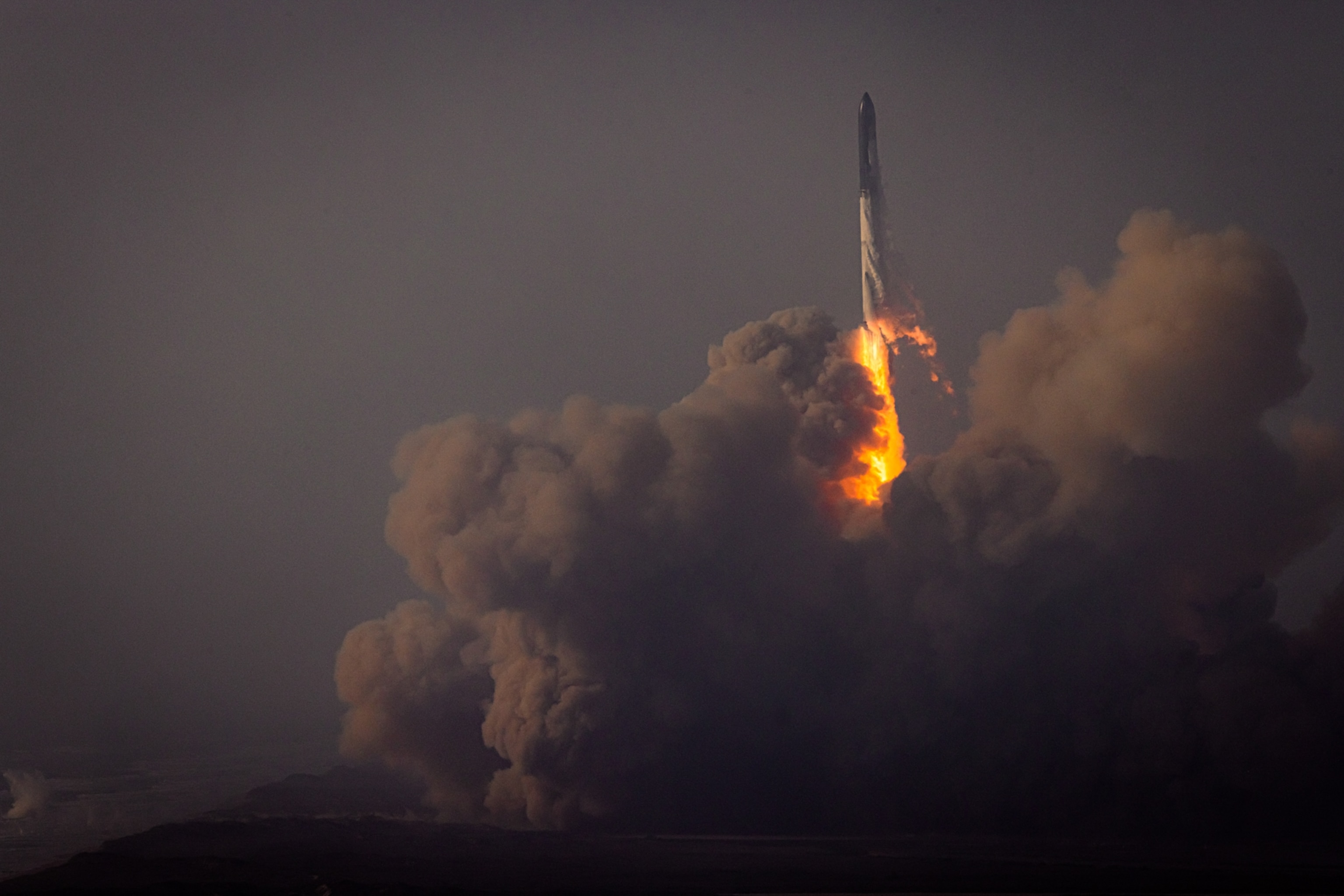 SpaceX's Starship leaves a fiery trail an an enormous bloom of smoke as it blasts off in Boca Chica, Texas.