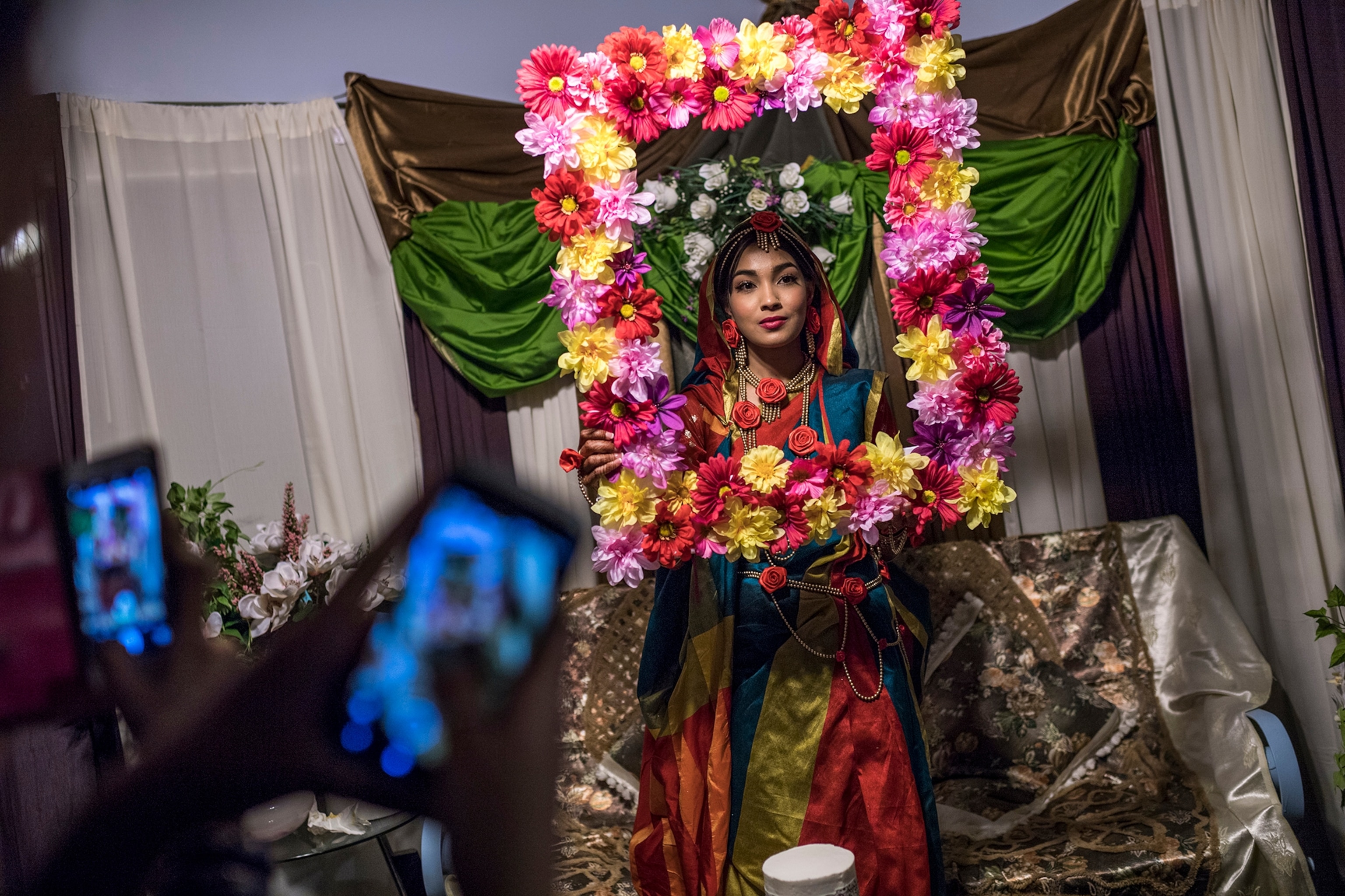 a Bangladeshi-American bridge holding a picture frame adorned with flowers