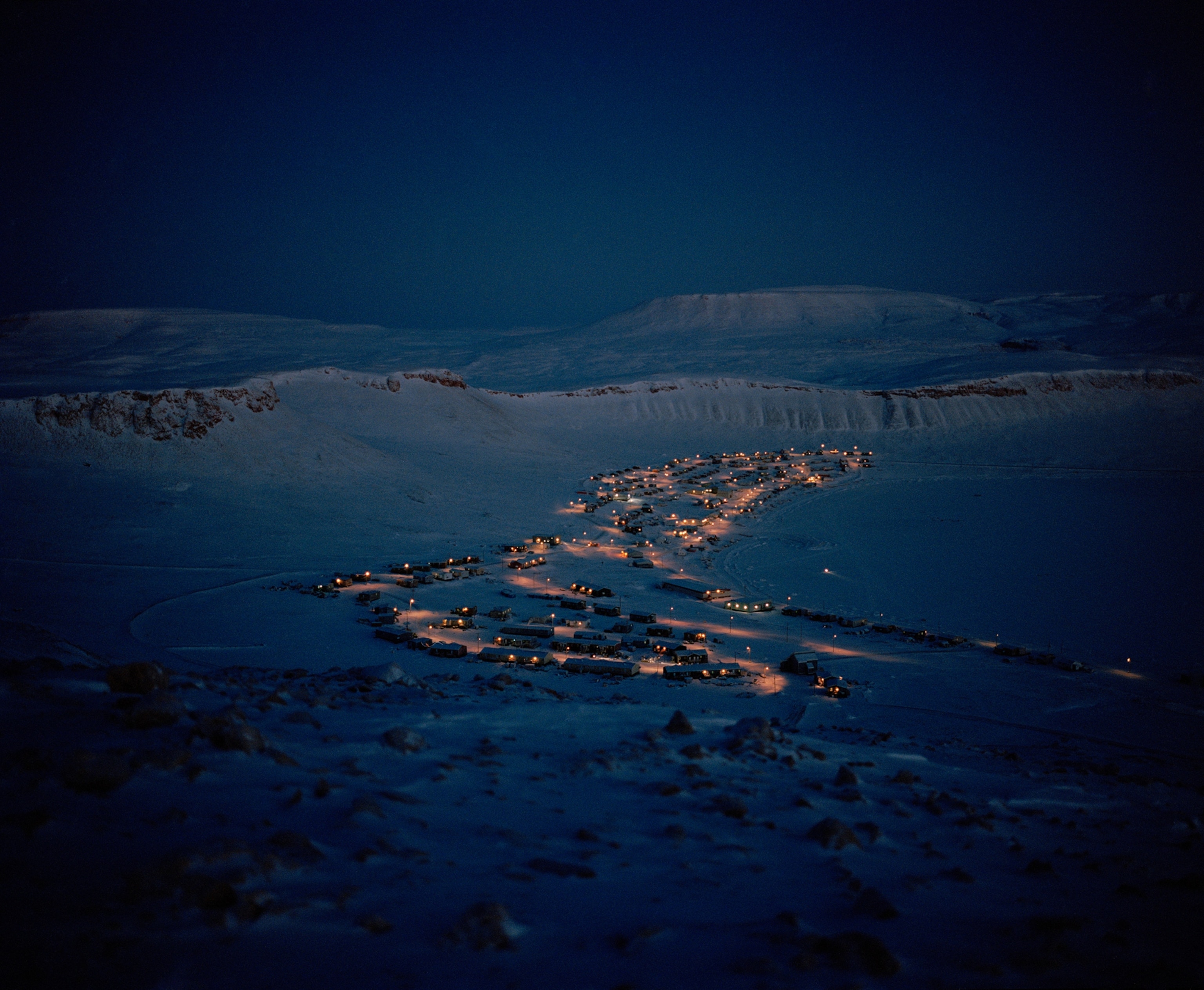 In December, the village of Arctic Bay, Nunavut glows through the winter darkness.
