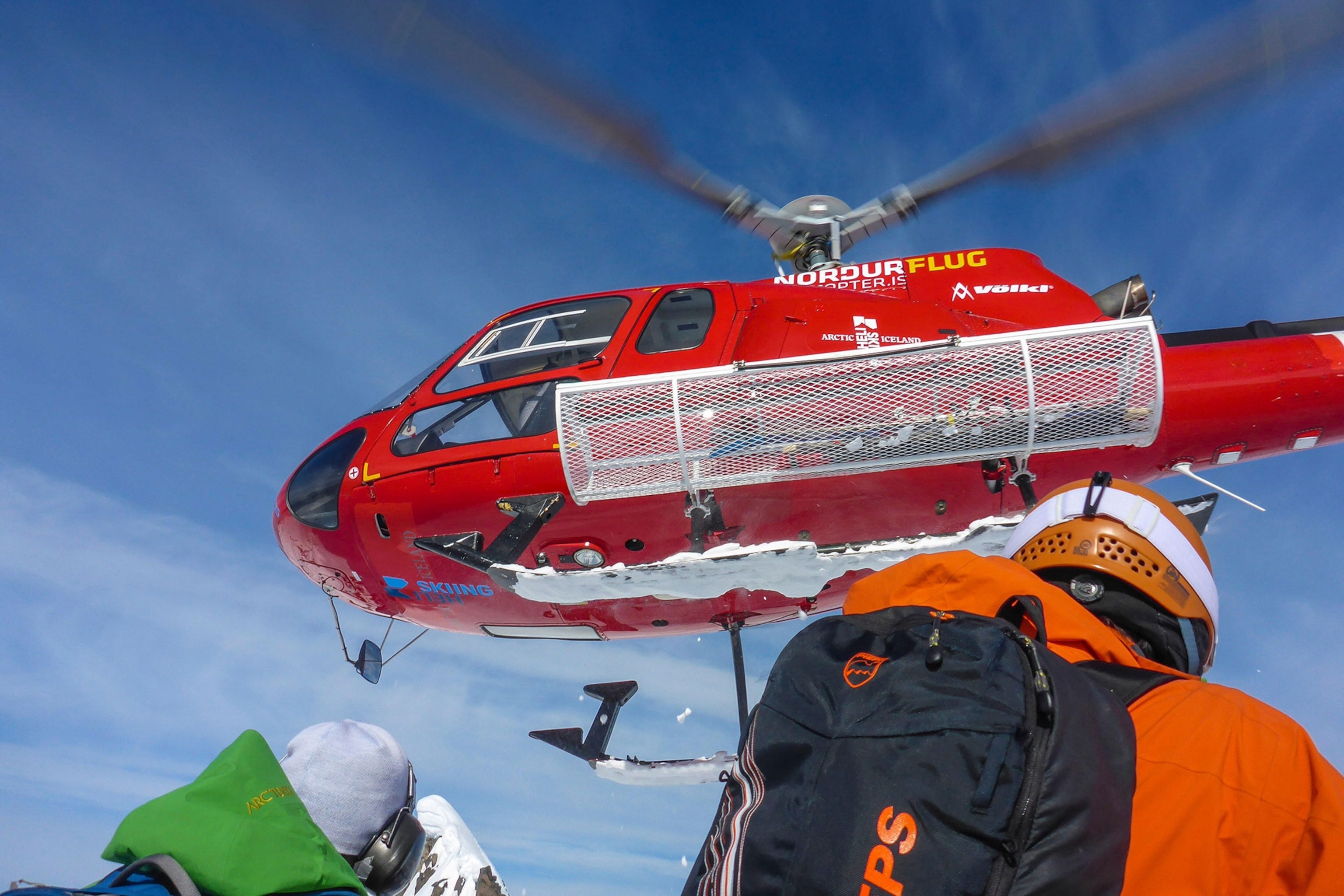 a group of skiers being dropped of by a helicopter in Iceland