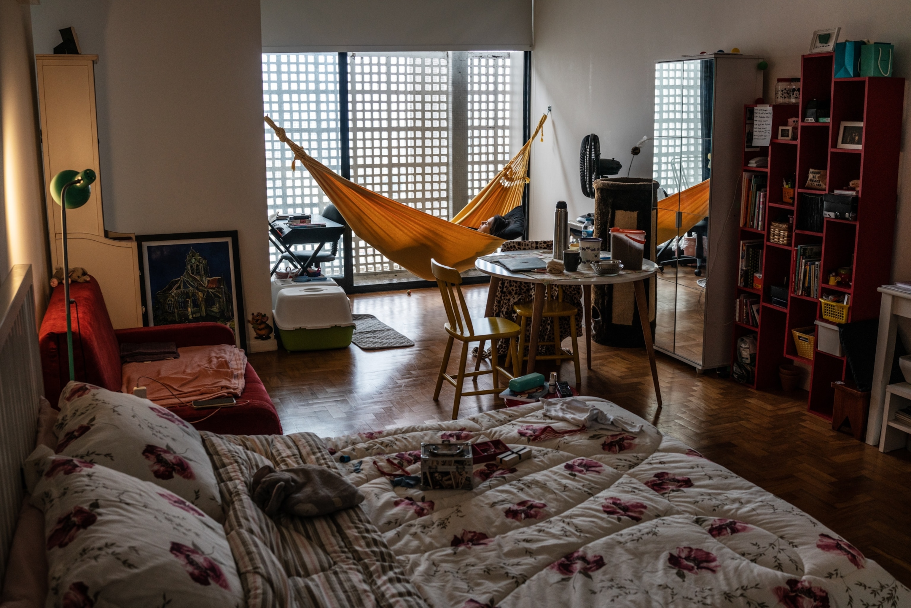 the interior of a room with a woman lounging on a yellow hammock