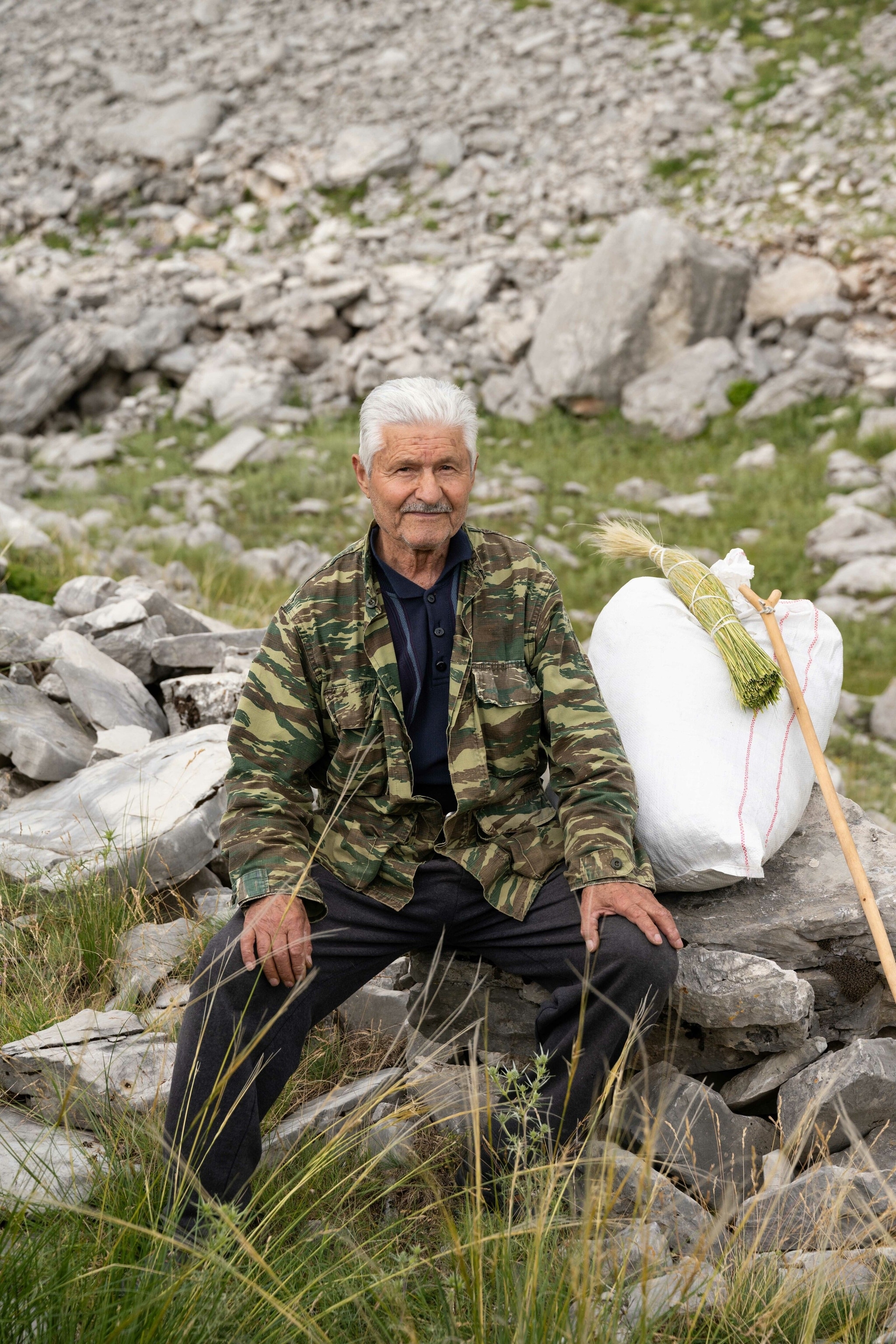 Christos, an 80-year-old local resident, rests after a morning picking herbs for Greek “mountain tea” on the slopes of the Lakmos mountain.