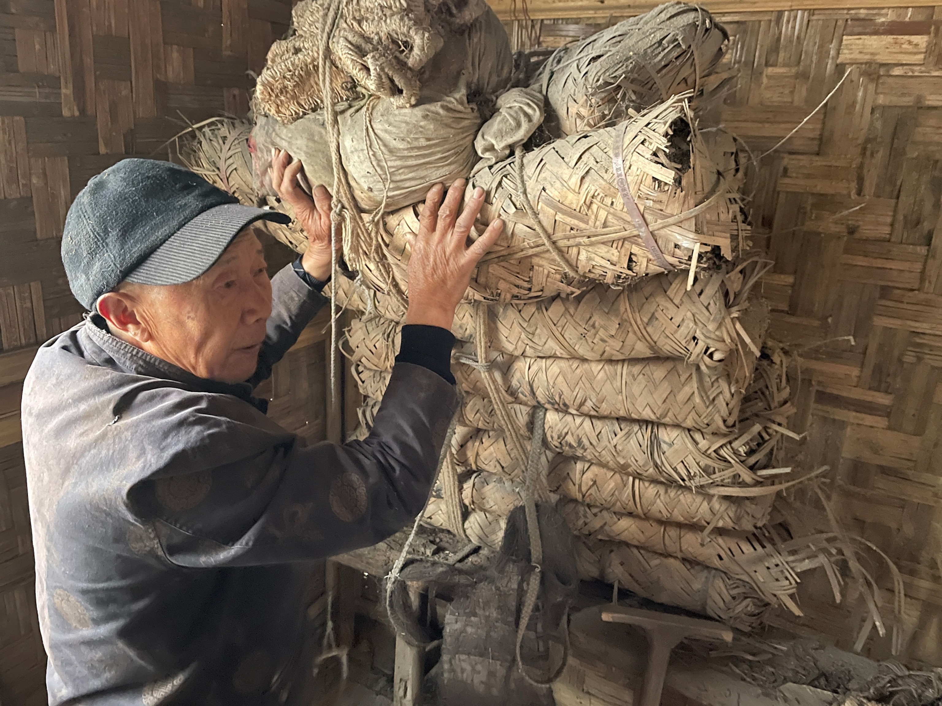 Photo of man showing tea bricks used in the past