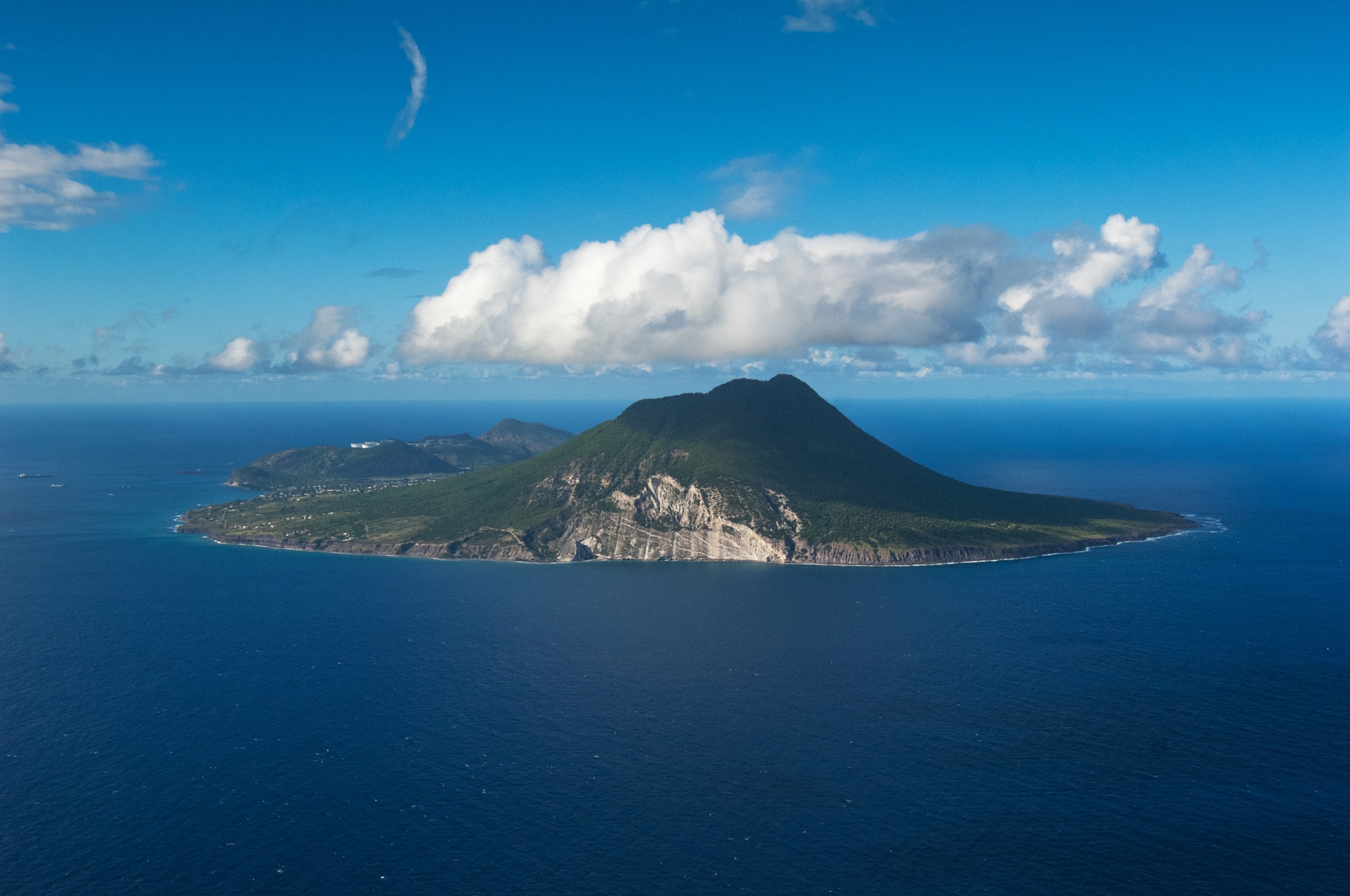 The island of St. Eustatius surrounded by ocean, one single cloud passes by
