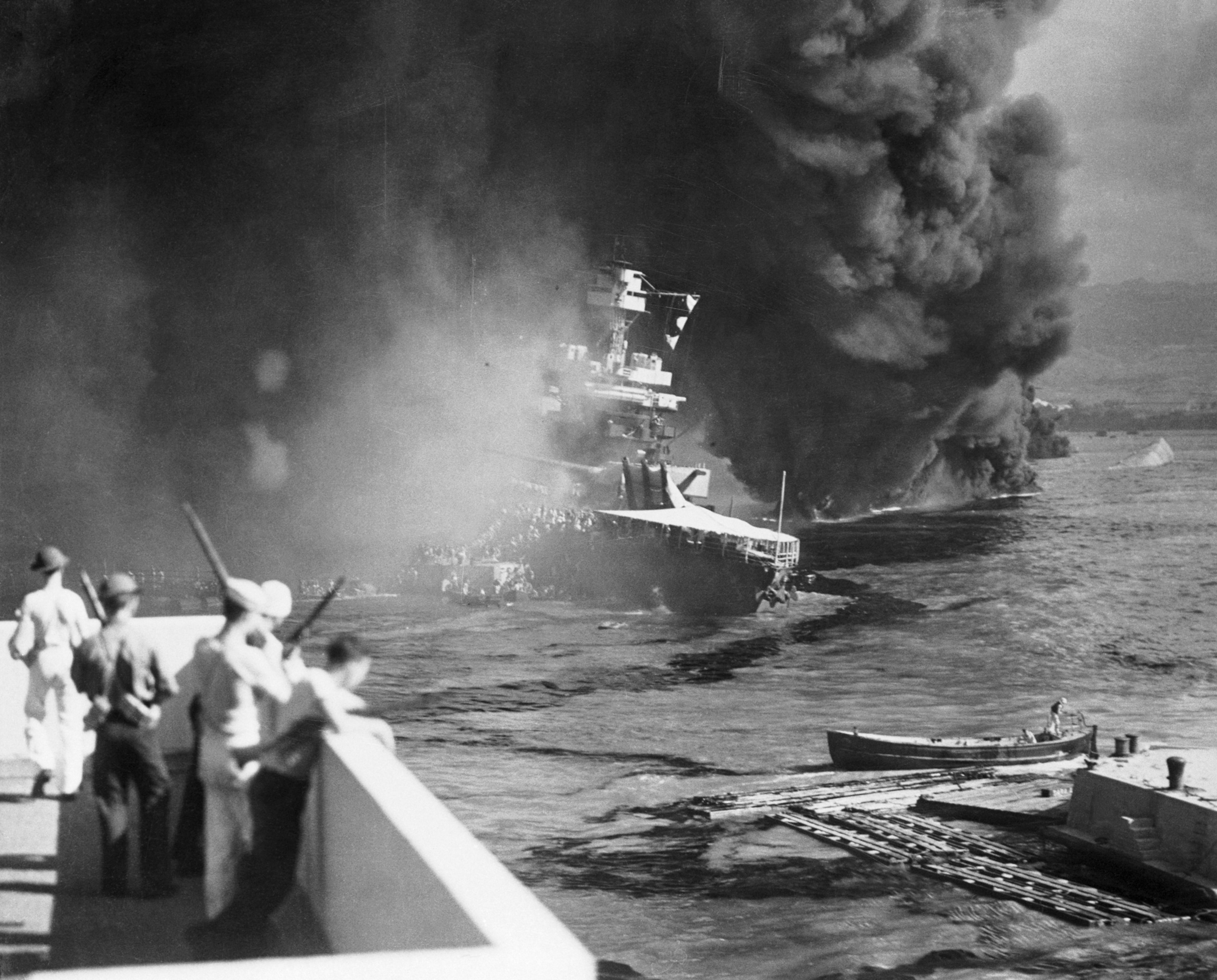 Hundreds of sailers evacuating a smoking ship.