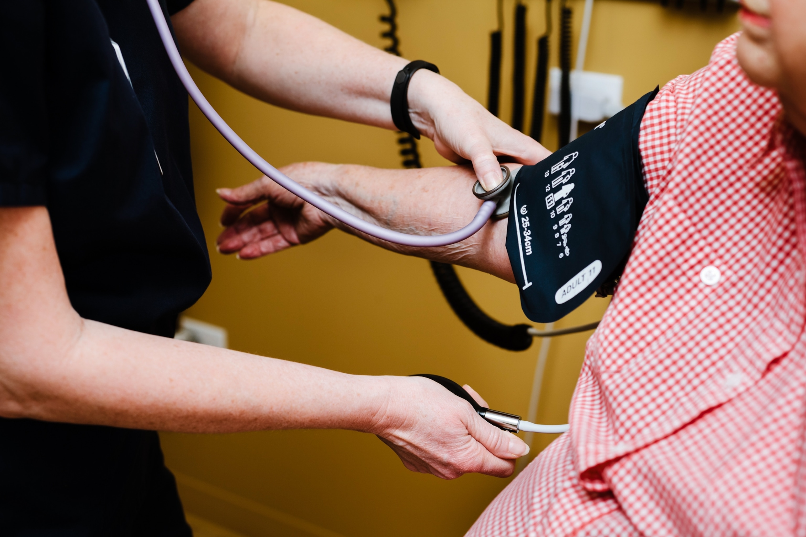 A close up view of a woman having her blood pressure checked during a clinic visit.