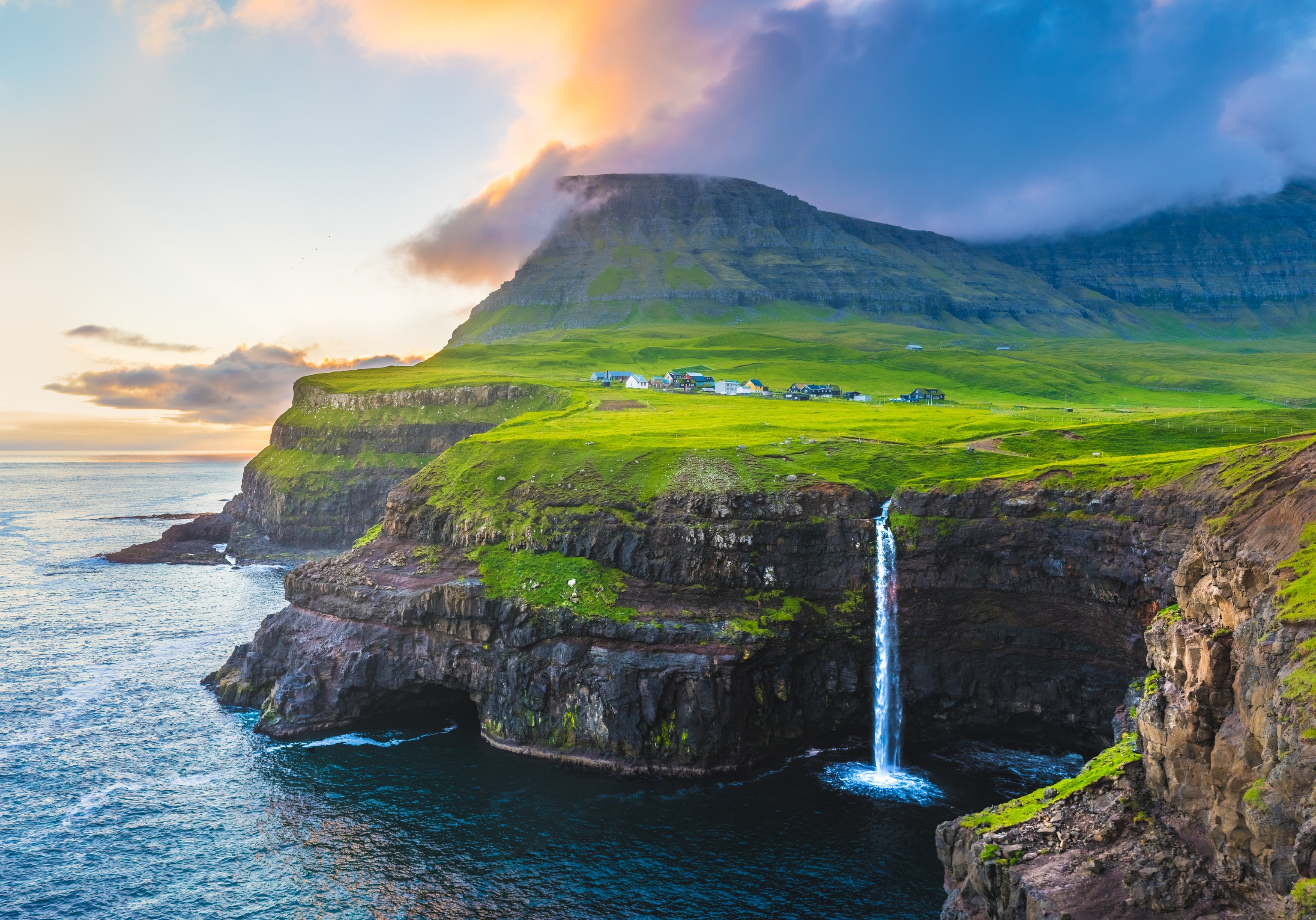 A view of Mulafossur Waterfall along the cliffs of the Faroe Islands.