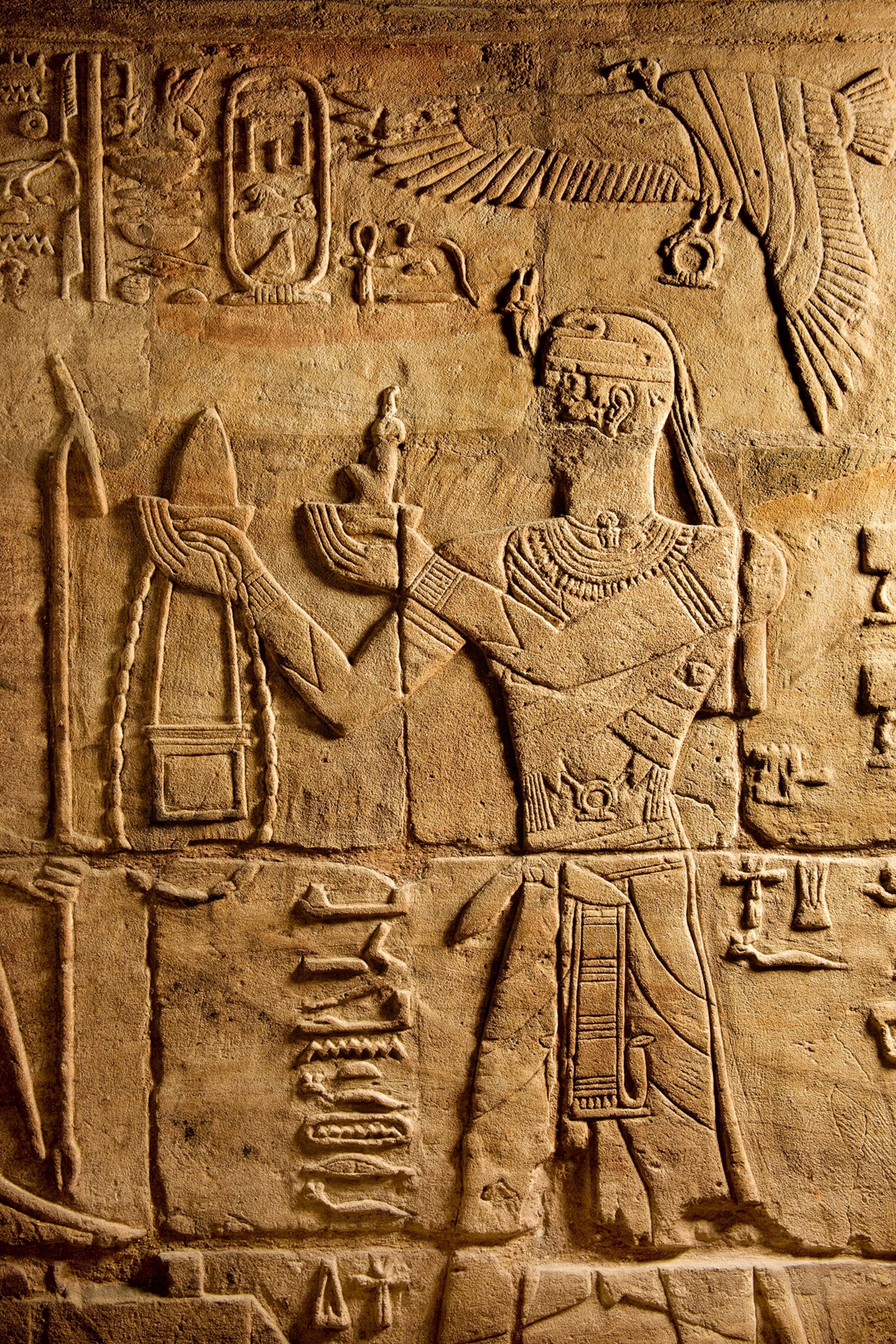 A relief shows a man on his knees making an offering to a god