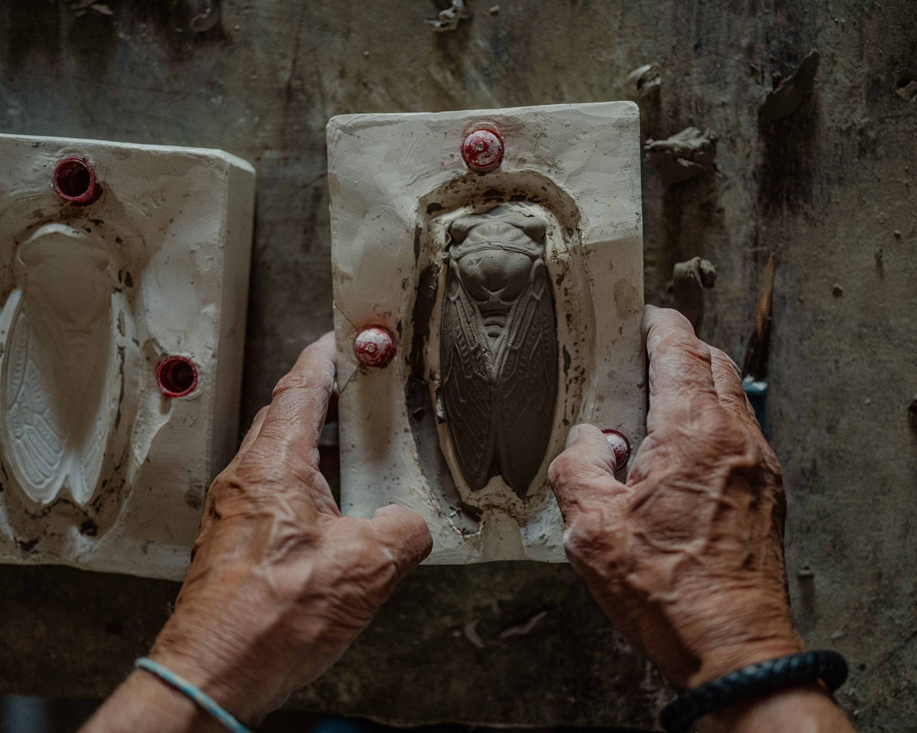 Bernard Amy takes takes the clay out of the cicada mold.