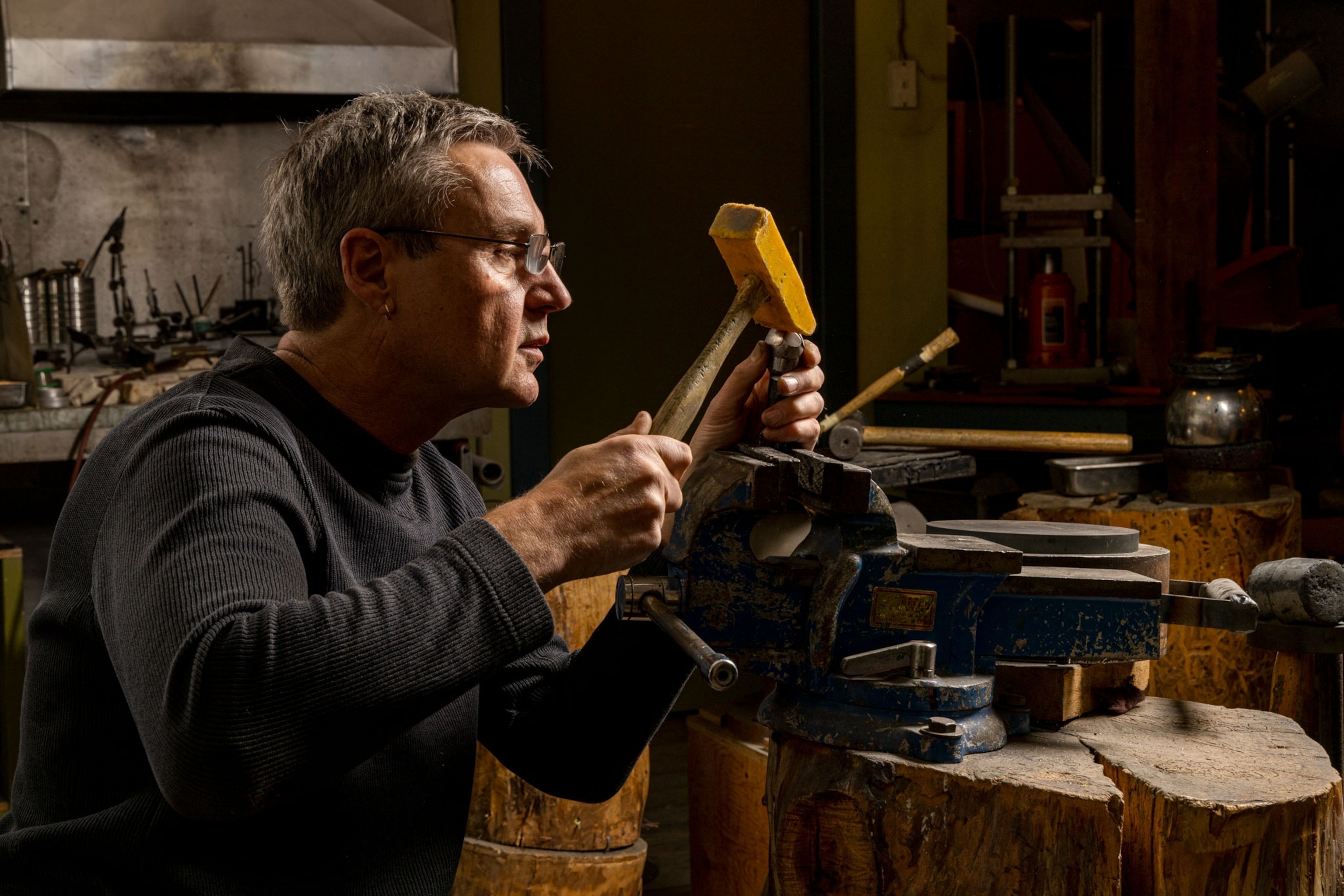 a metal artist works in his studio