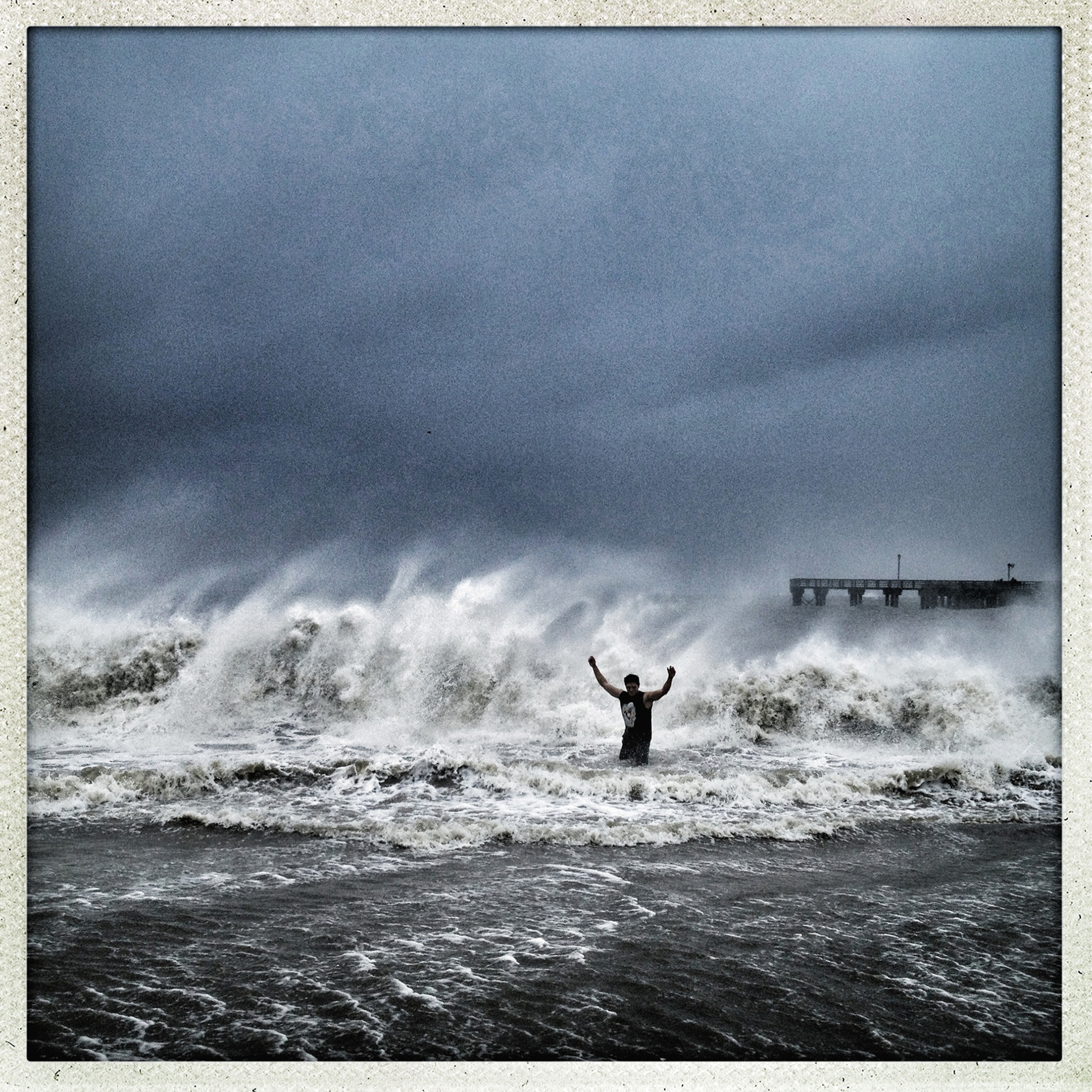 a man standing in ocean waves during Hurricane Sandy