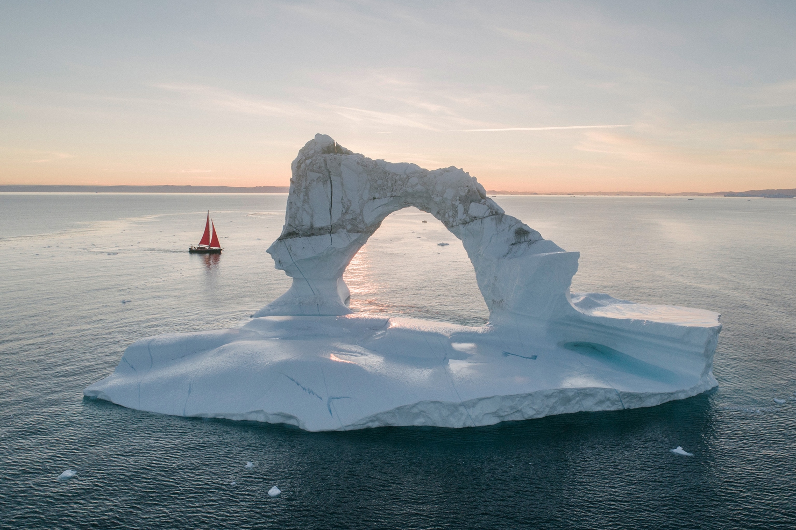 a tourist boat sailing around an iceberg in Greenland