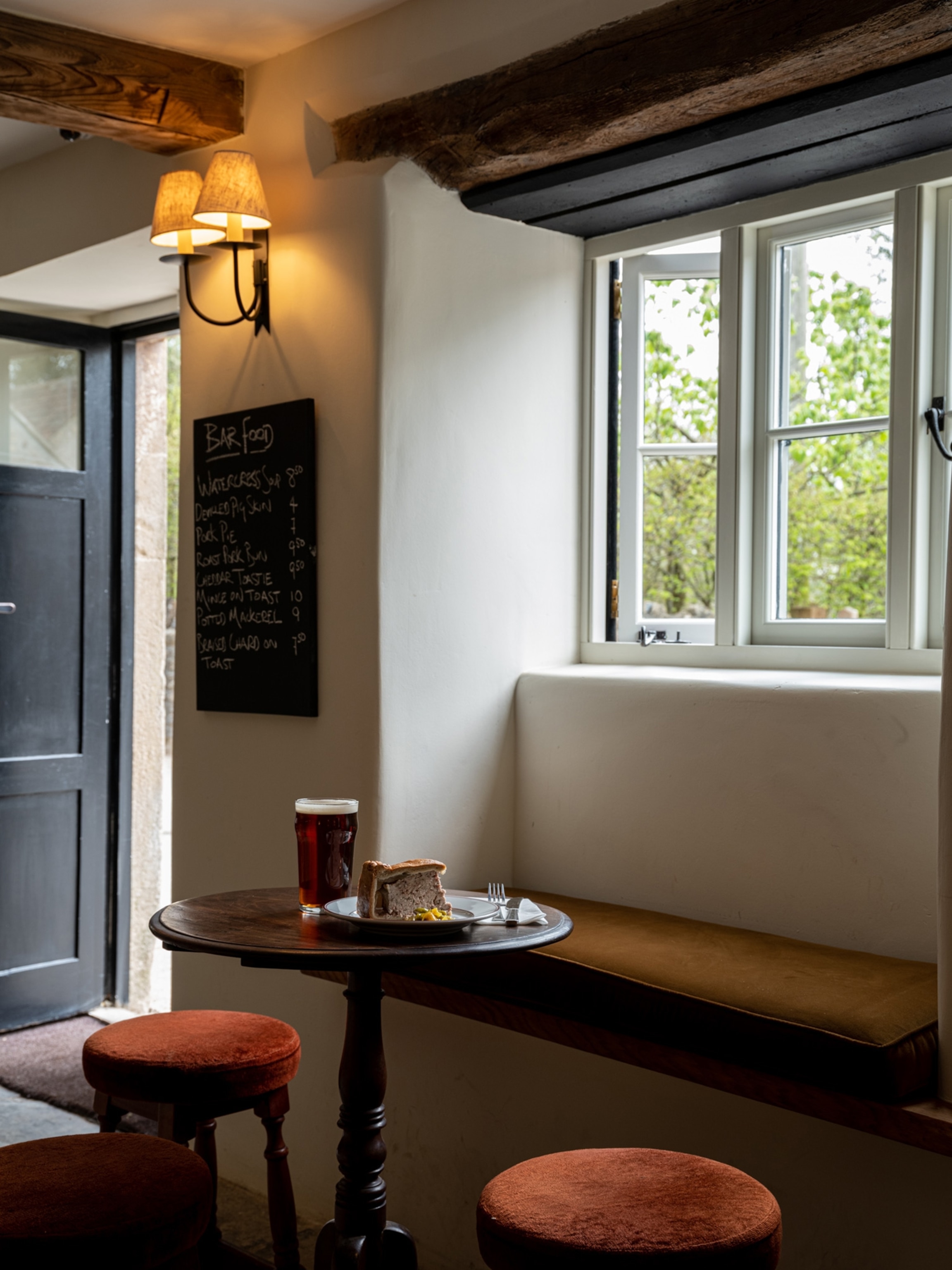 A plate sits on a table near a window in the dining room of The Three Horseshoes.