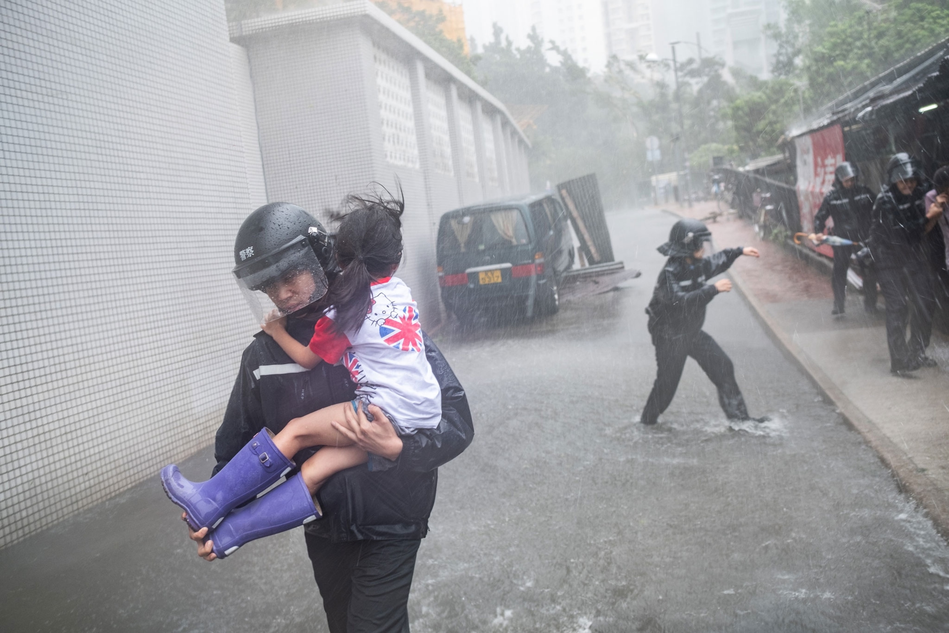 police officers rushing a young girl out of a collapsed school in Hong Kong.