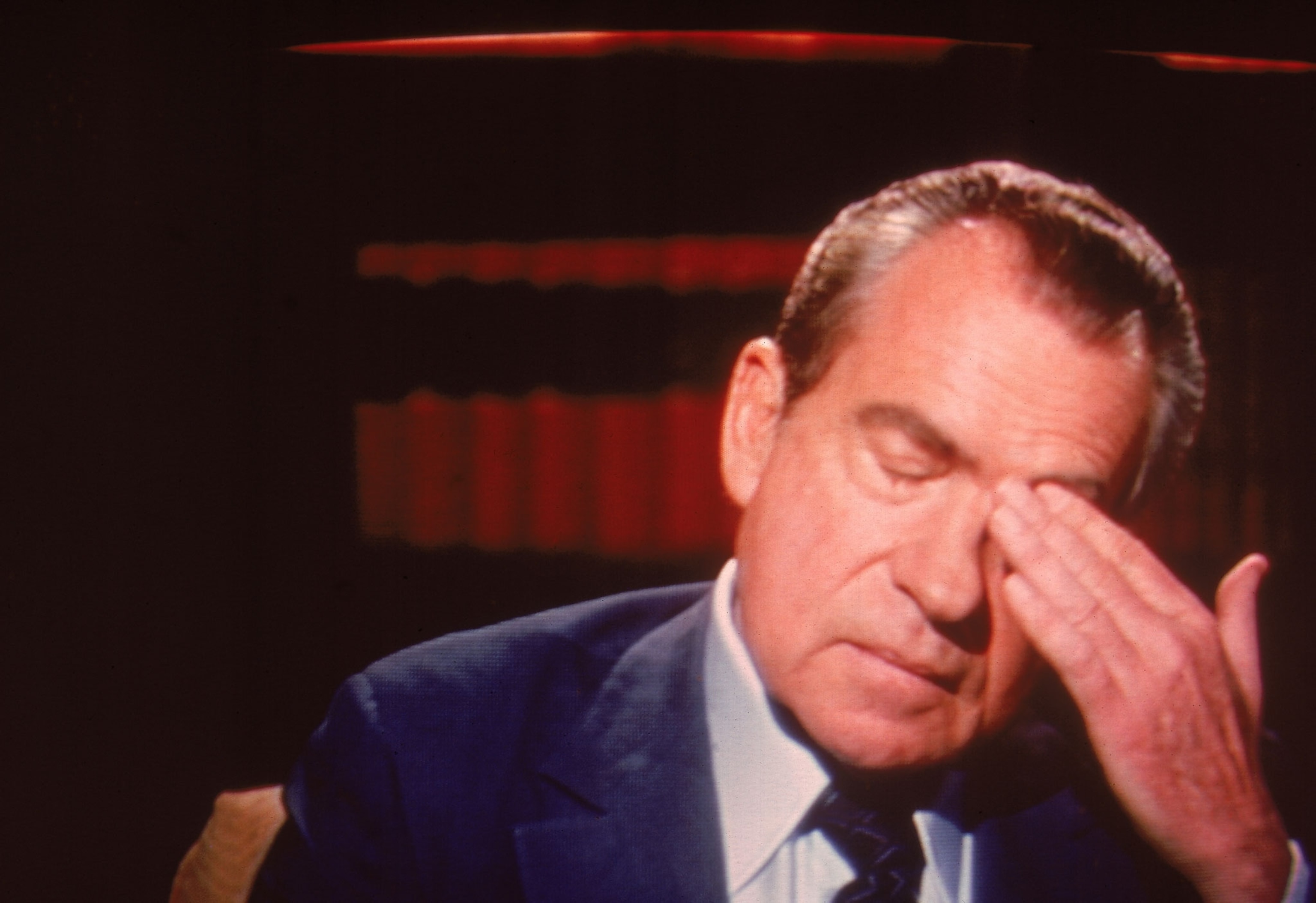 President Nixon rubs his forehead with his eyes closed