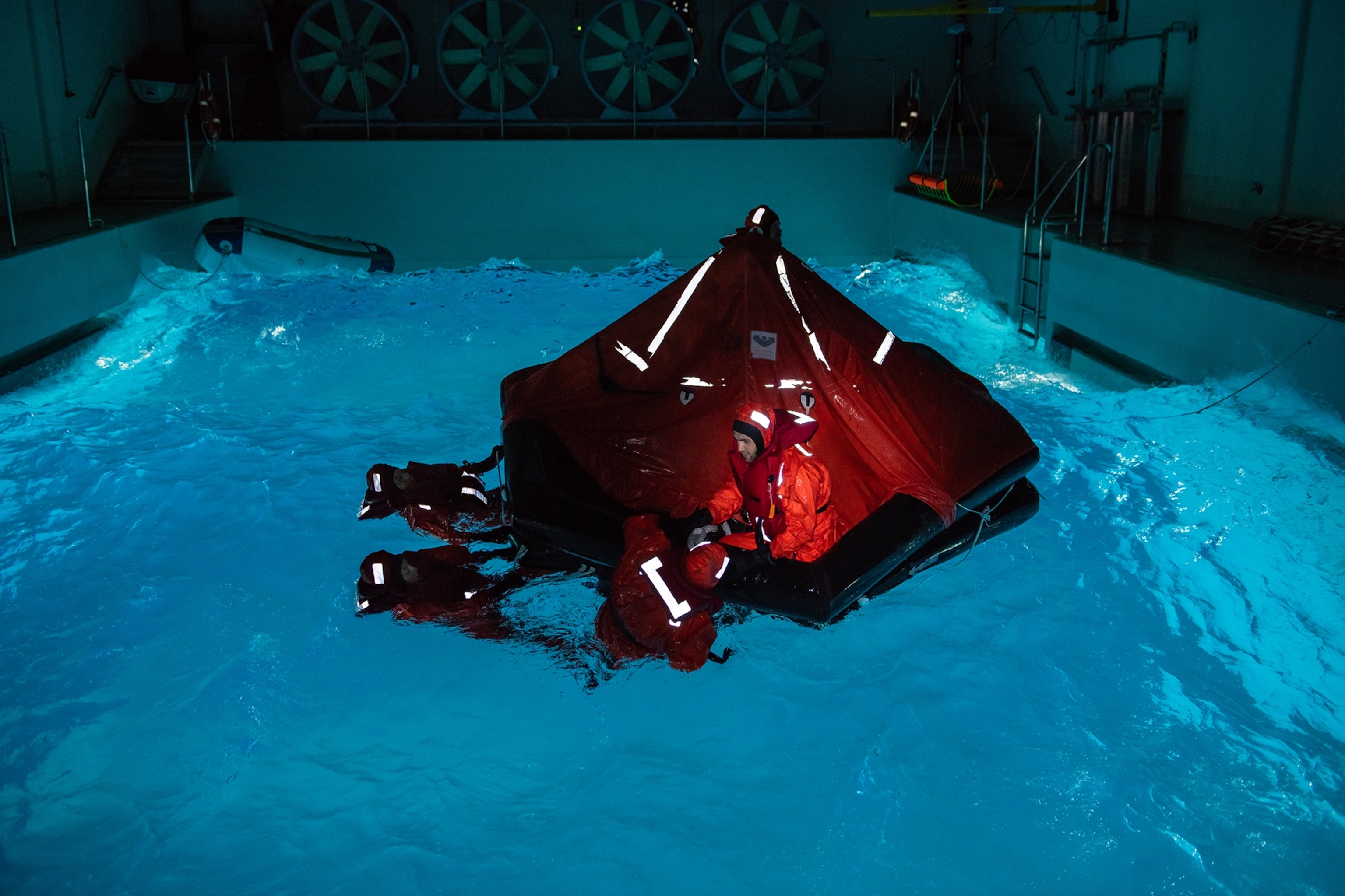 participants training on ow to get in a life raft in a specialized pool