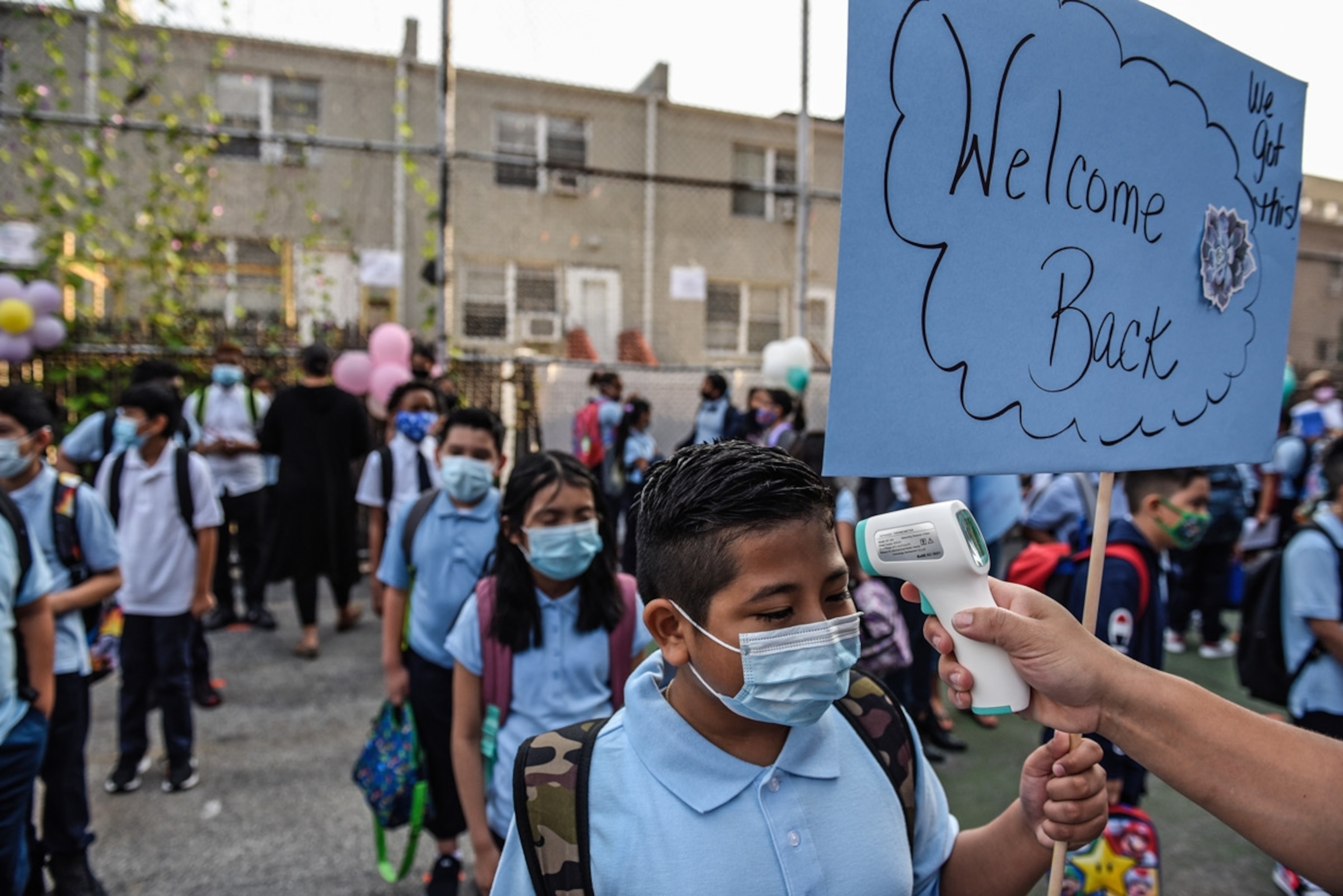 Students wait in line to get their temperature taken before entering a public school on the first day of classes in the Bronx borough in New York, U.S., on Monday, Sept. 13, 2021. For the first time since the beginning of the Covid-19 pandemic, all of New York Citys public school students are expected to return to classes in person on Monday.