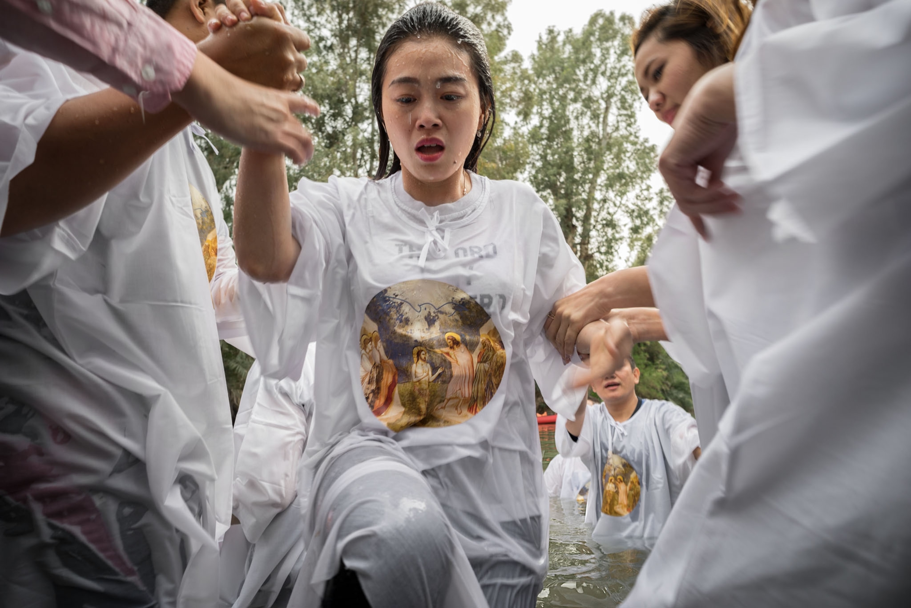 Indonesian Christian woman wearing a gown depicting Jesus after baptism in Jordan River.