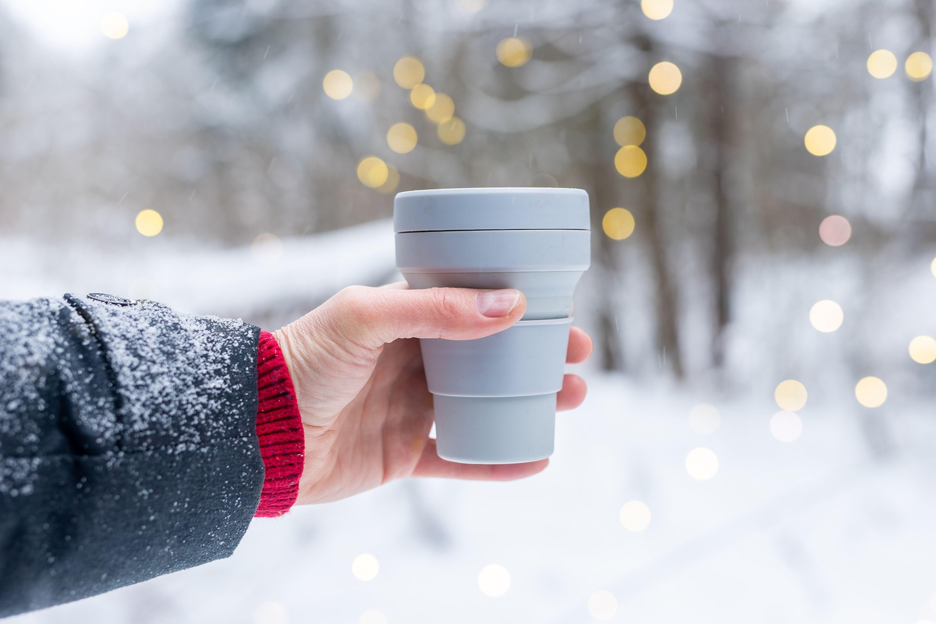 A close up photograph of a hand holding a cup.