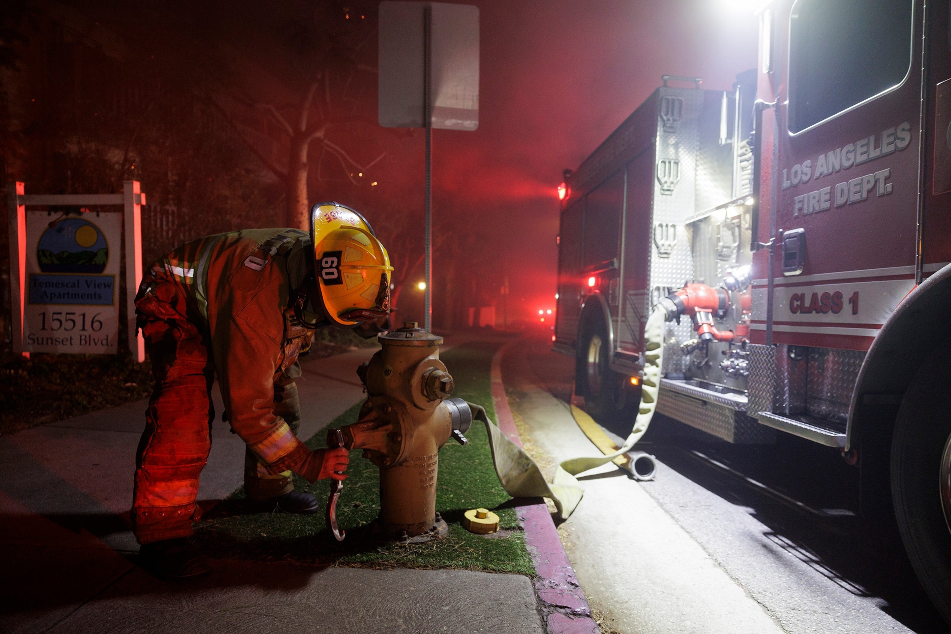 A Los Angeles Fire Department firefighter opens up a hydrant in an effort to put out a burning apartment complex caused by the rapidly spreading Palisades Fire in Pacific Palisades neighborhood in Los Angeles, Calif., on Tuesday, Jan. 7, 2025. The fire has destroyed dozens of homes and prompting evacuation orders for about 30,000 people.