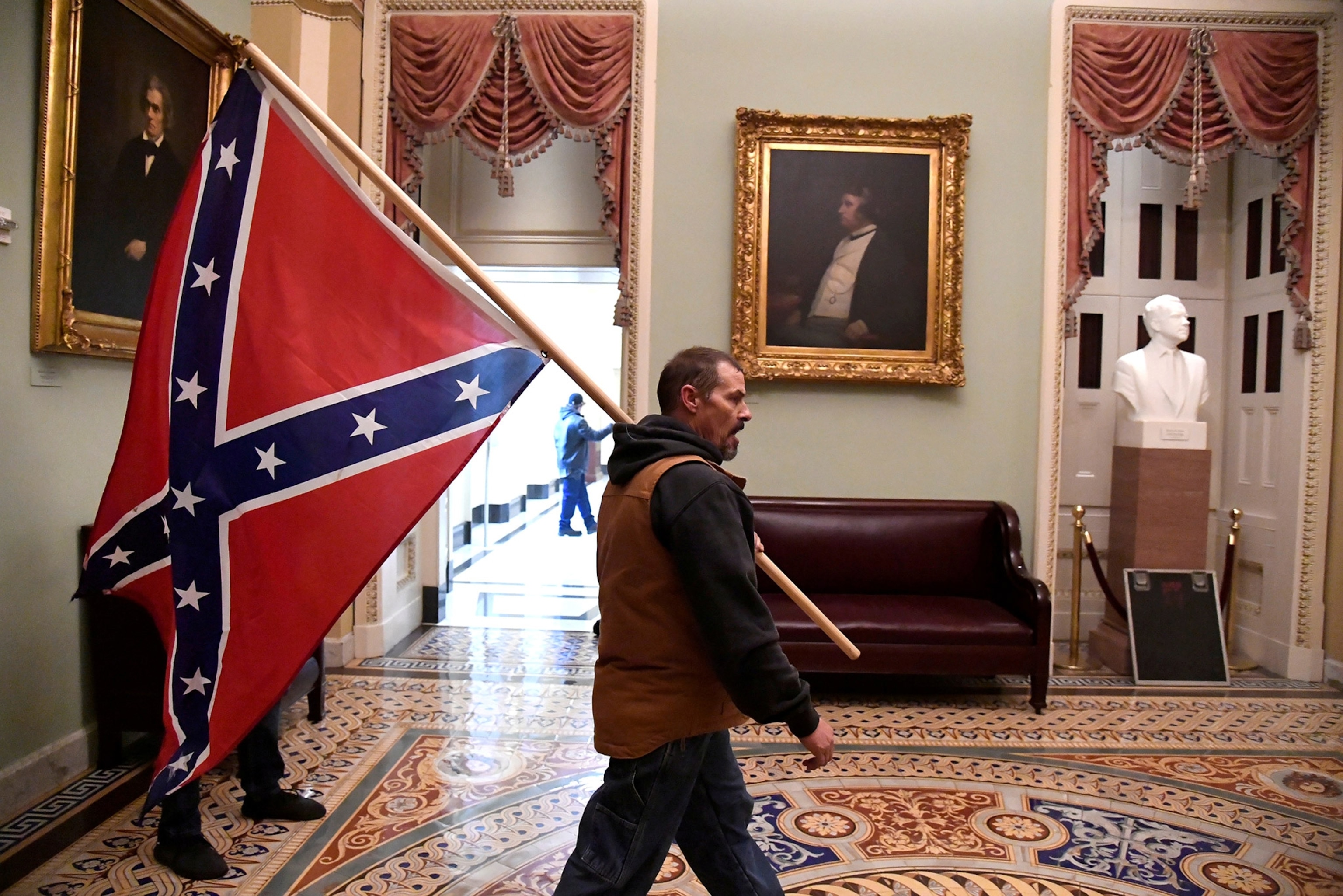 A supporter of President Donald Trump carries a Confederate battle flag in the U.S. Capitol