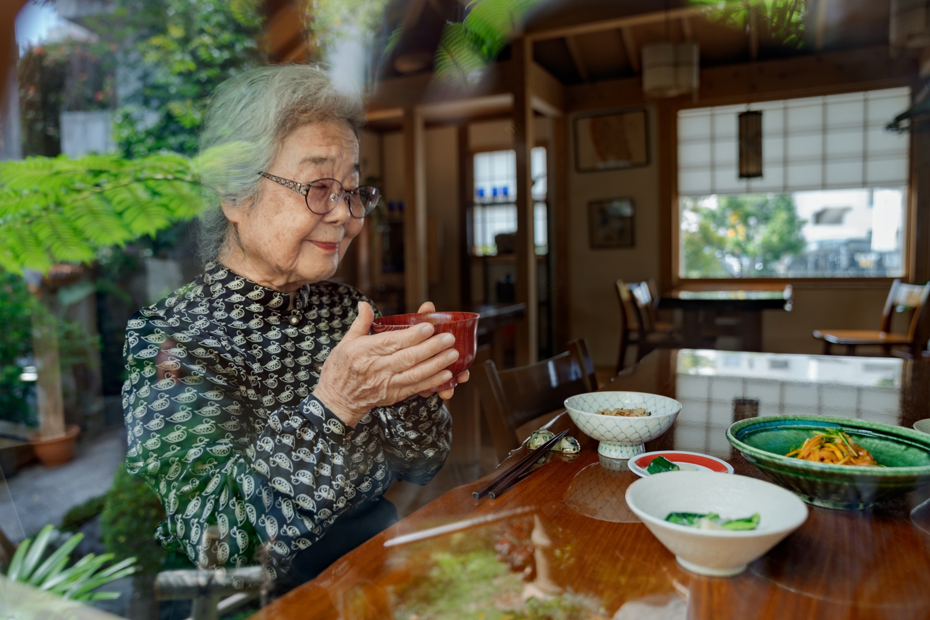 old woman holding red soup-bowl.