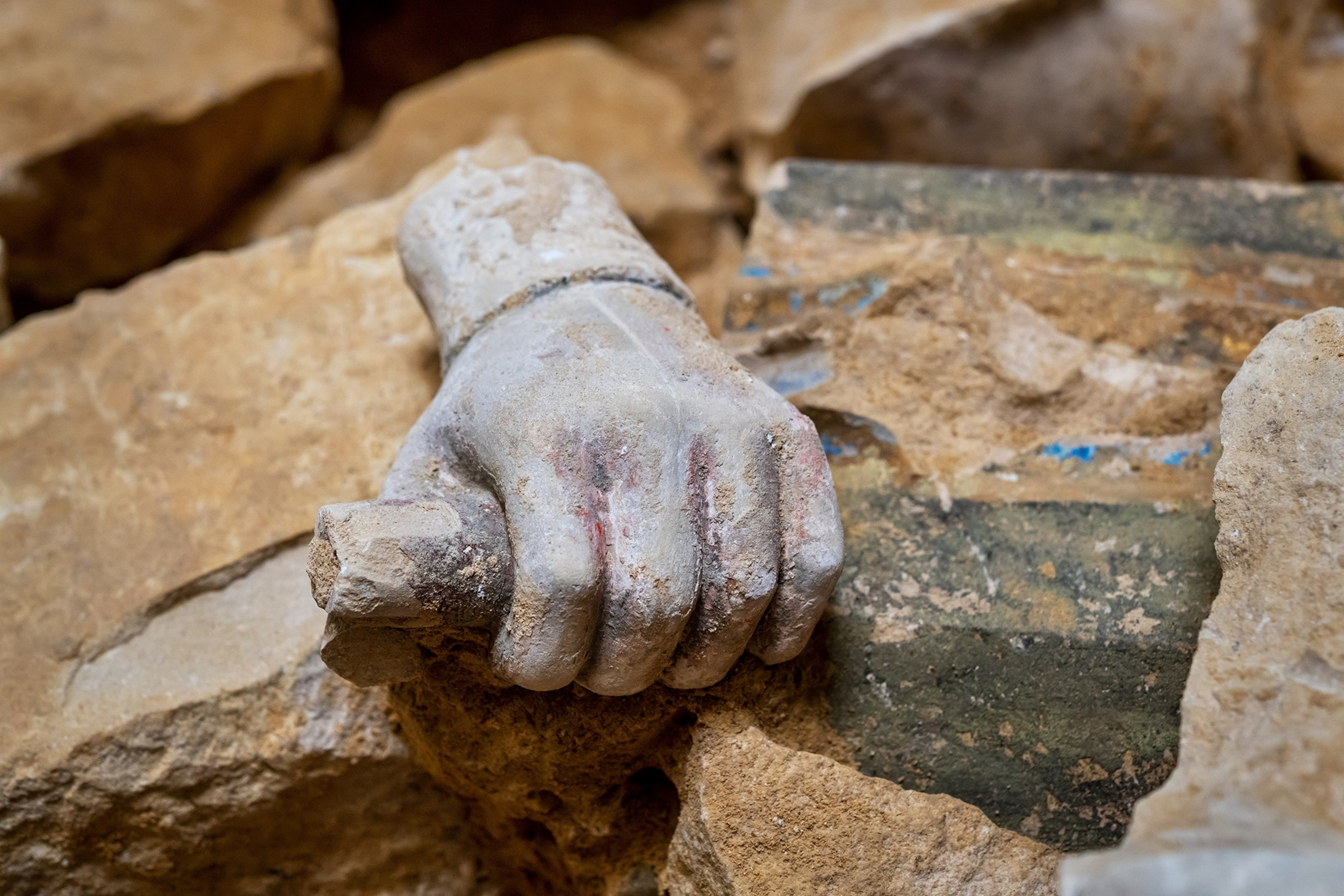 Detail of a hand from the Rood screen between rocks during excavations of the transept crossing of Notre-Dame de Paris.