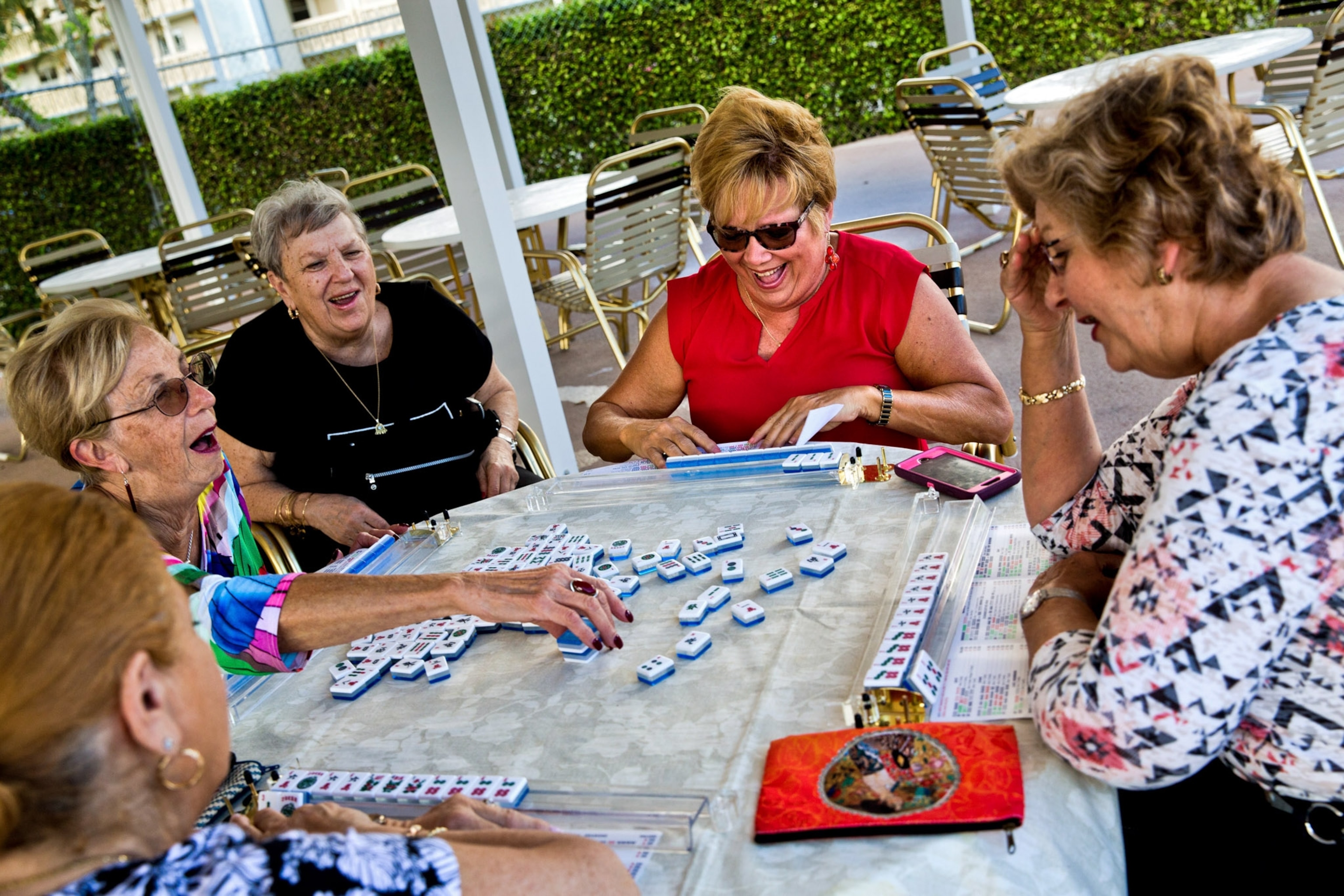 A group of women laugh playing mahjong