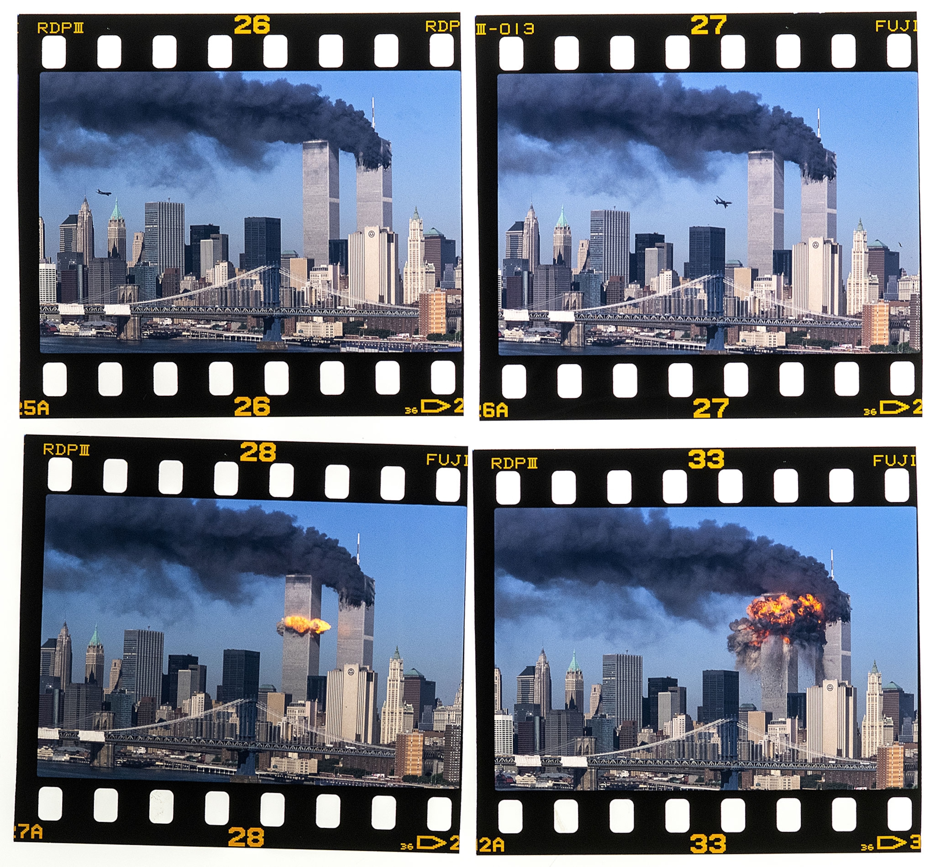 Four photo negatives showing smoke and flames billowing from the twin towers