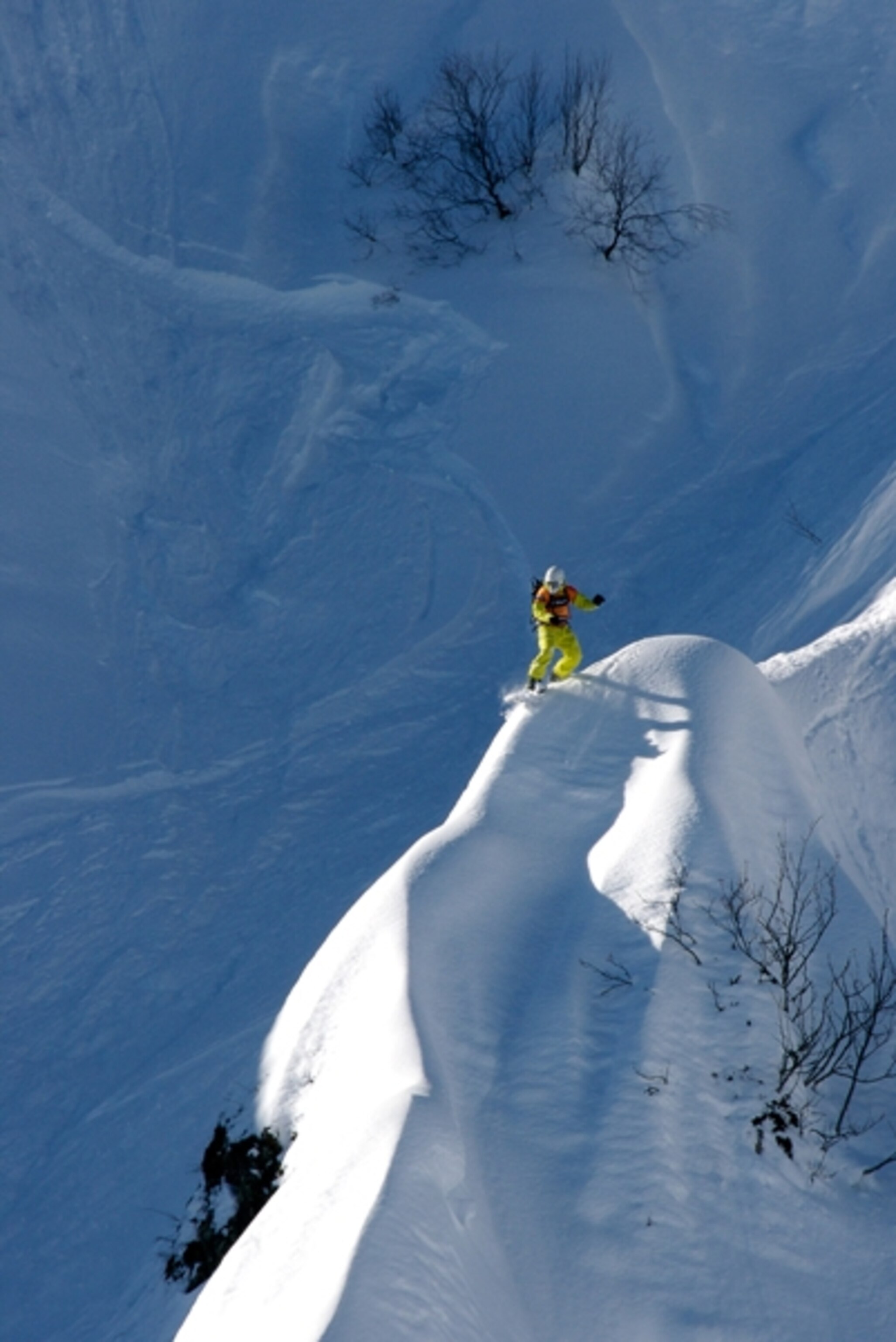 Snowboarder sits atop mountain peak