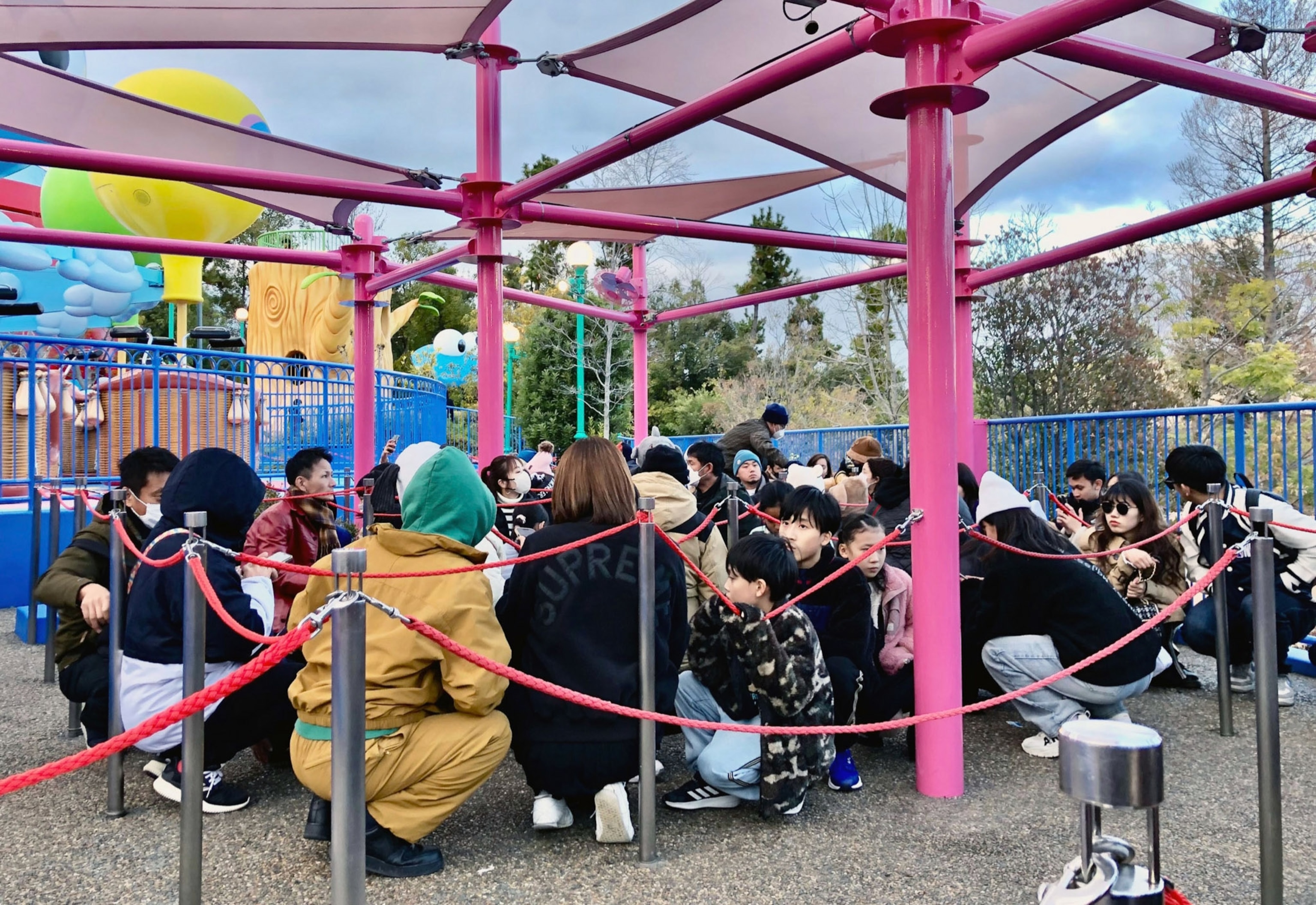 People crouch as a group together in a park.