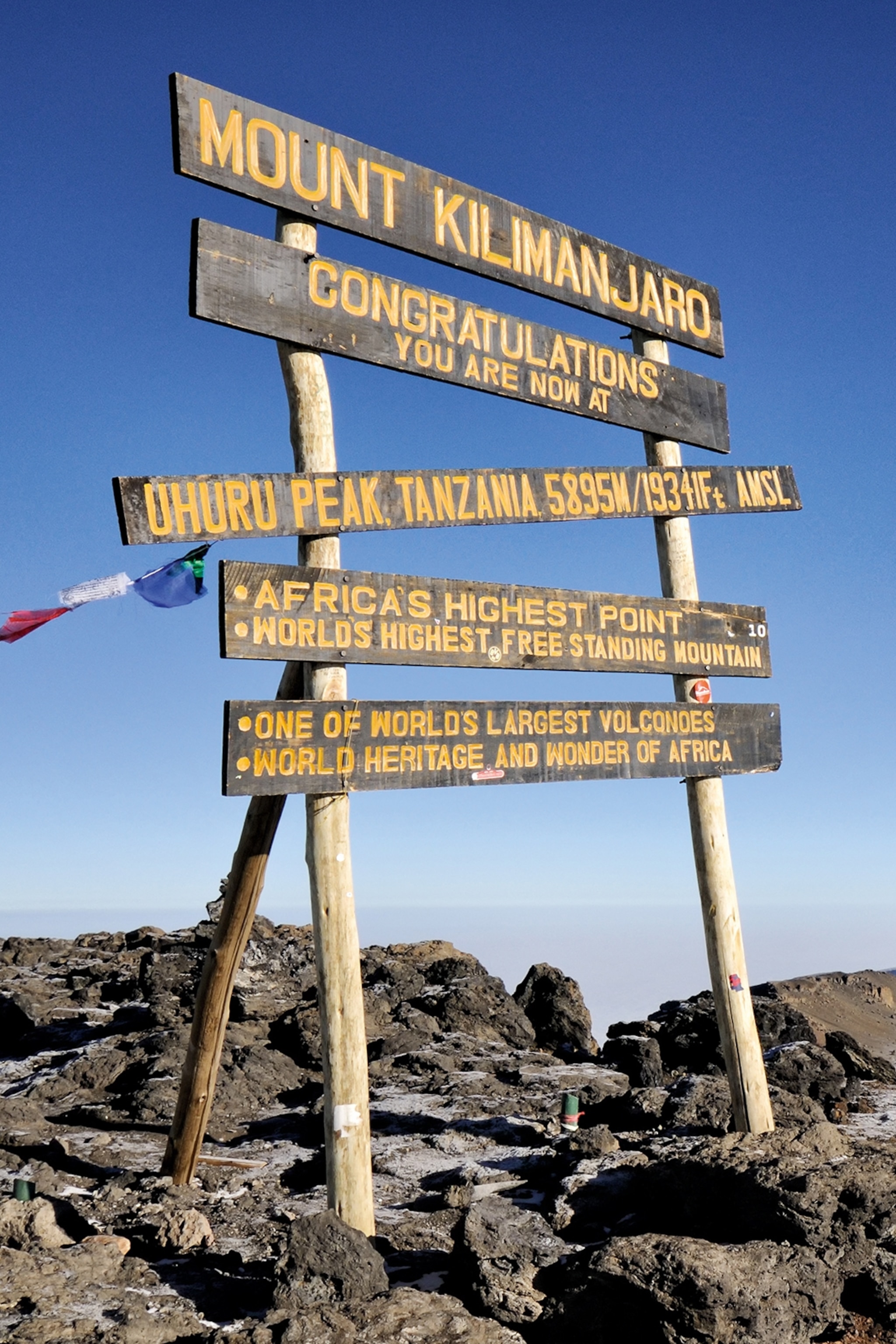 Africa’s highest points are pointed out on mount kilimanjaro with wooden hand-painted signs