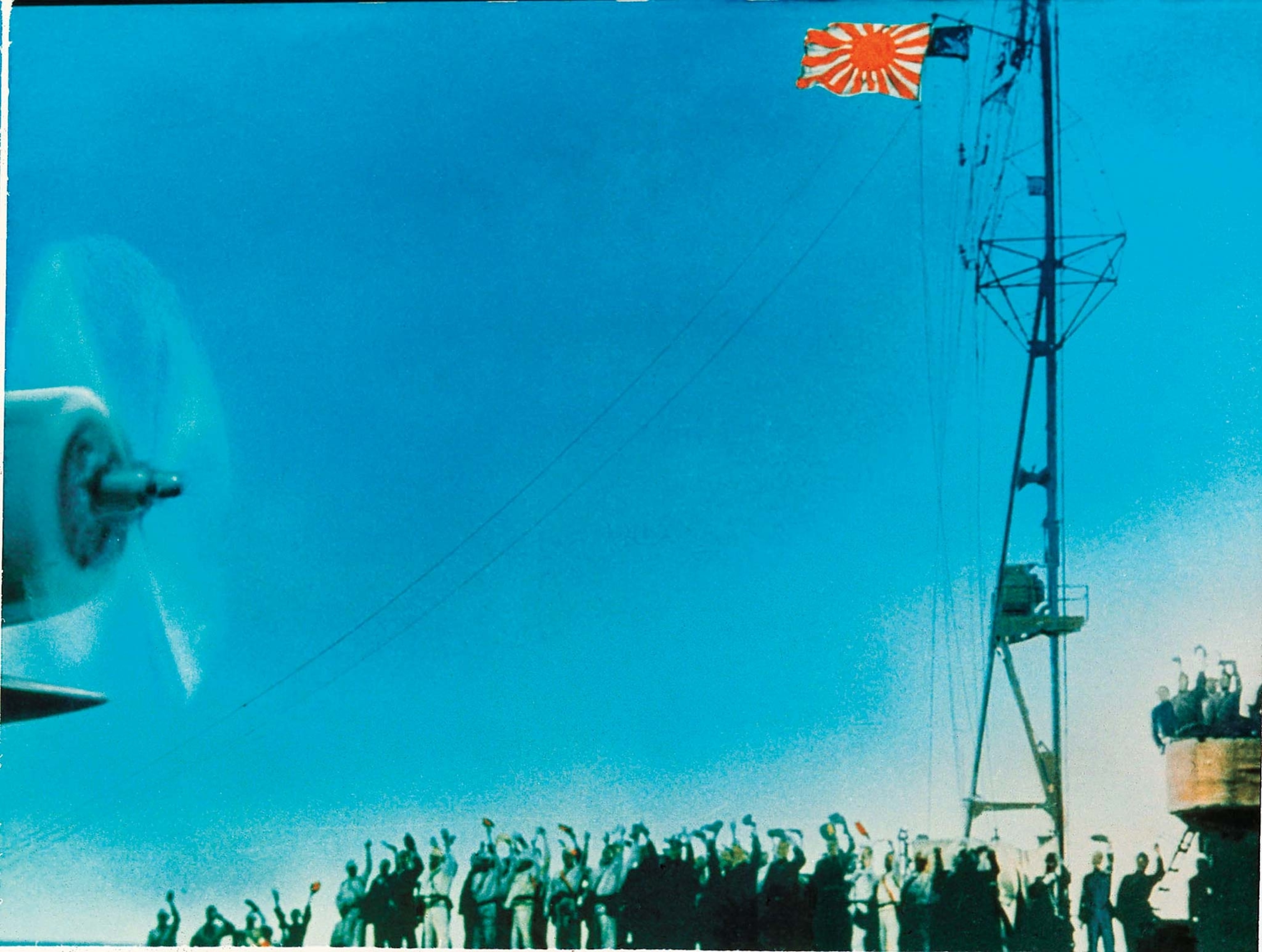 Crewmen on a Japanese aircraft carrier cheer as a warplane takes off