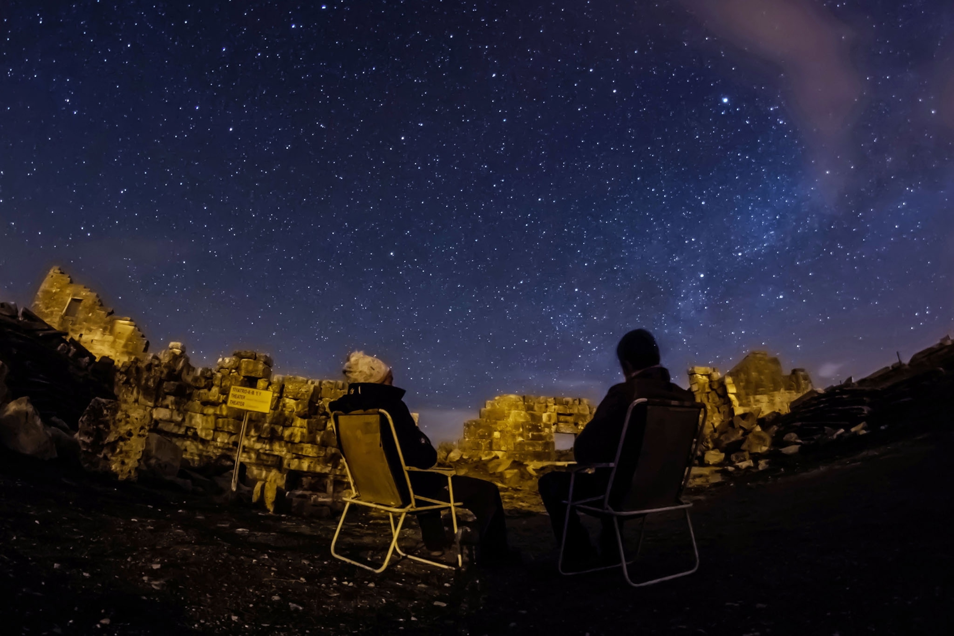 people lounging at night looking at the night sky