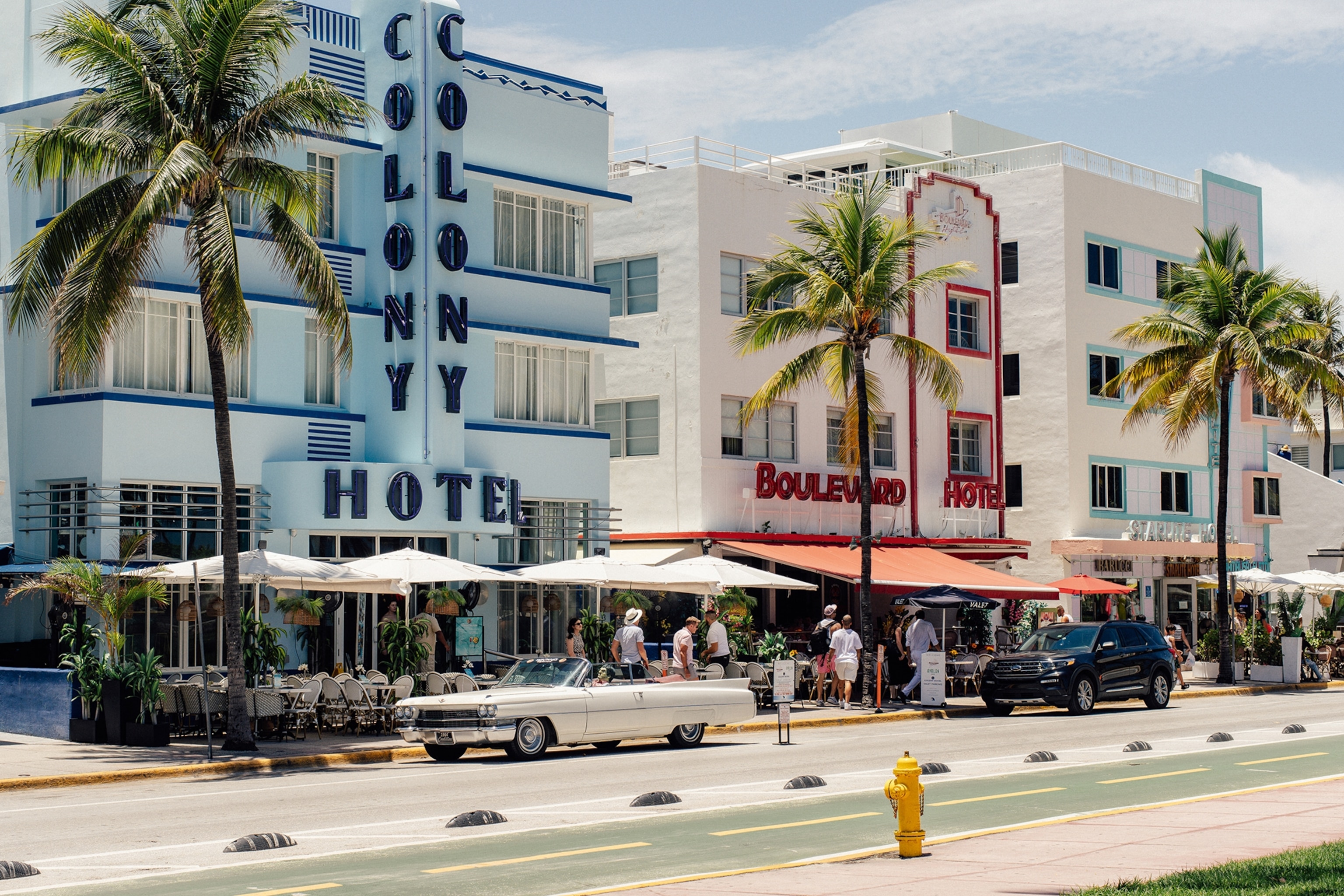 Retro white and blue hotels on a boulevard with palm trees
