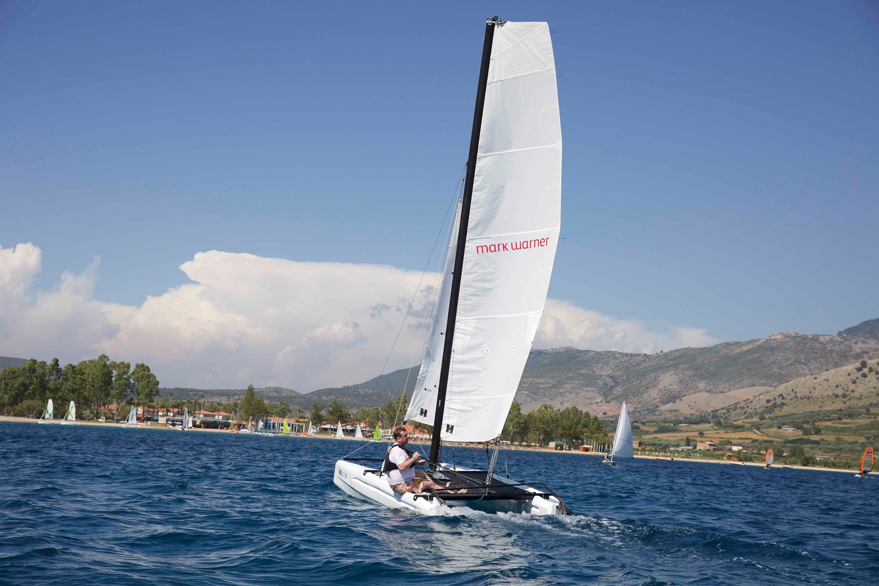 Person sitting on a sail boat dinghy-sailing in Greece.