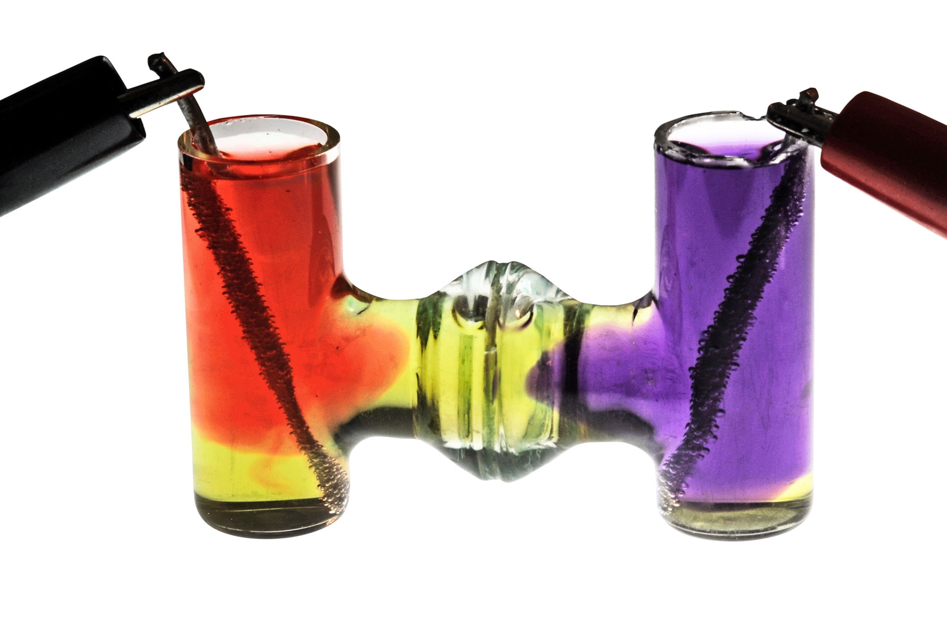 glass vessel in a shape of binocular with red and purple liquids.