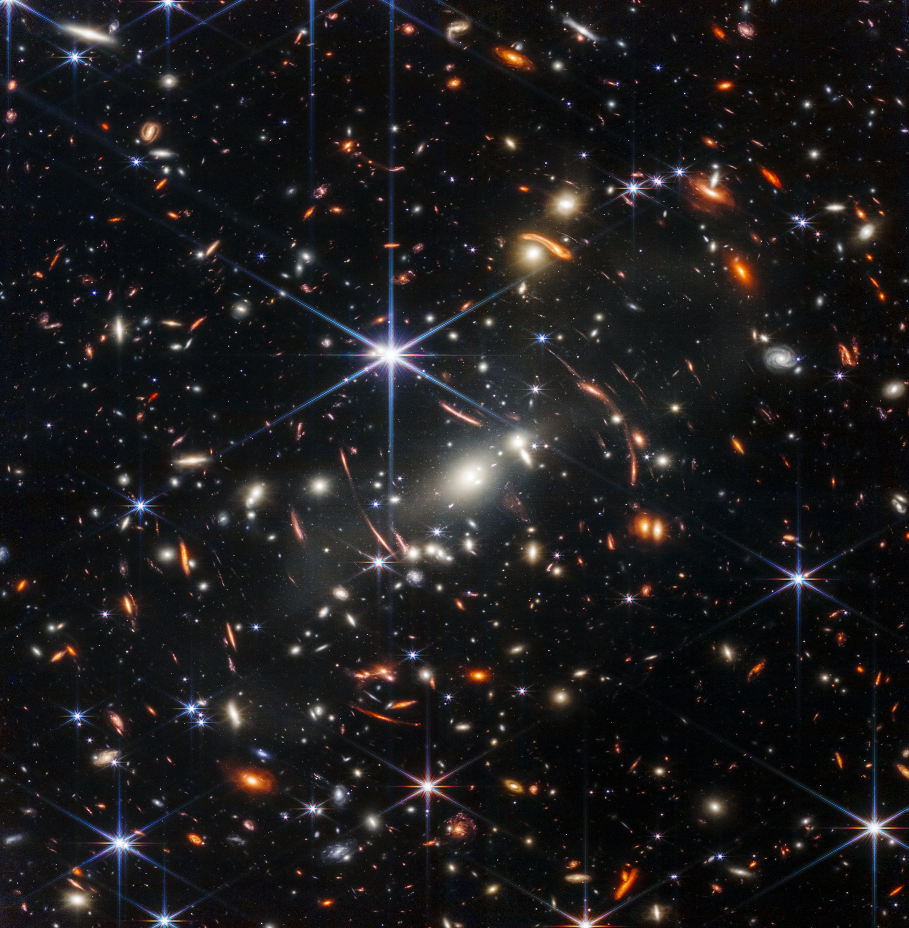 Colorful stars on black sky with one shining white star in the middle of frame.