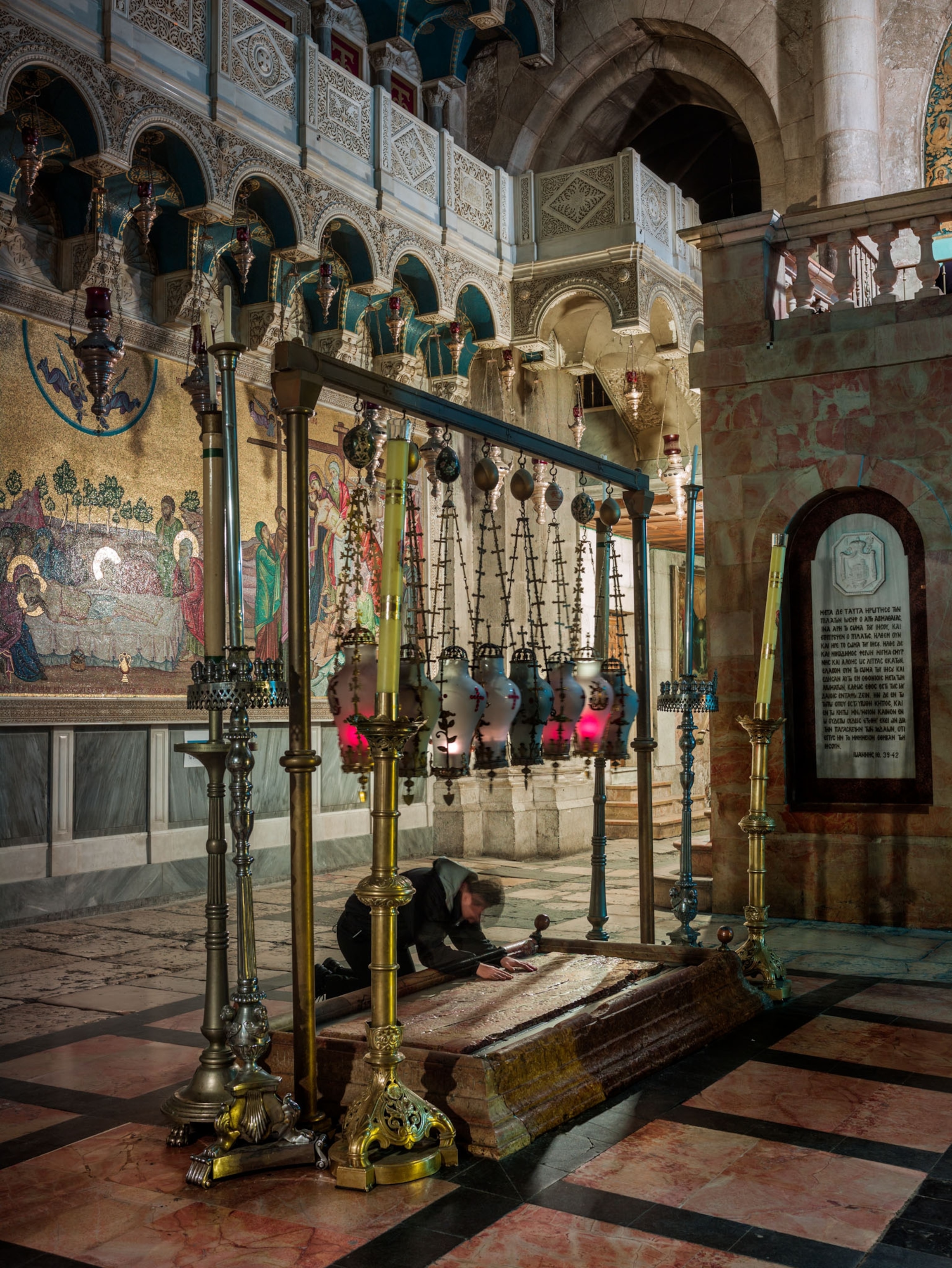 kneeling pilgrim inside the Church of the Holy Sepulchre at the Stone of Unction.