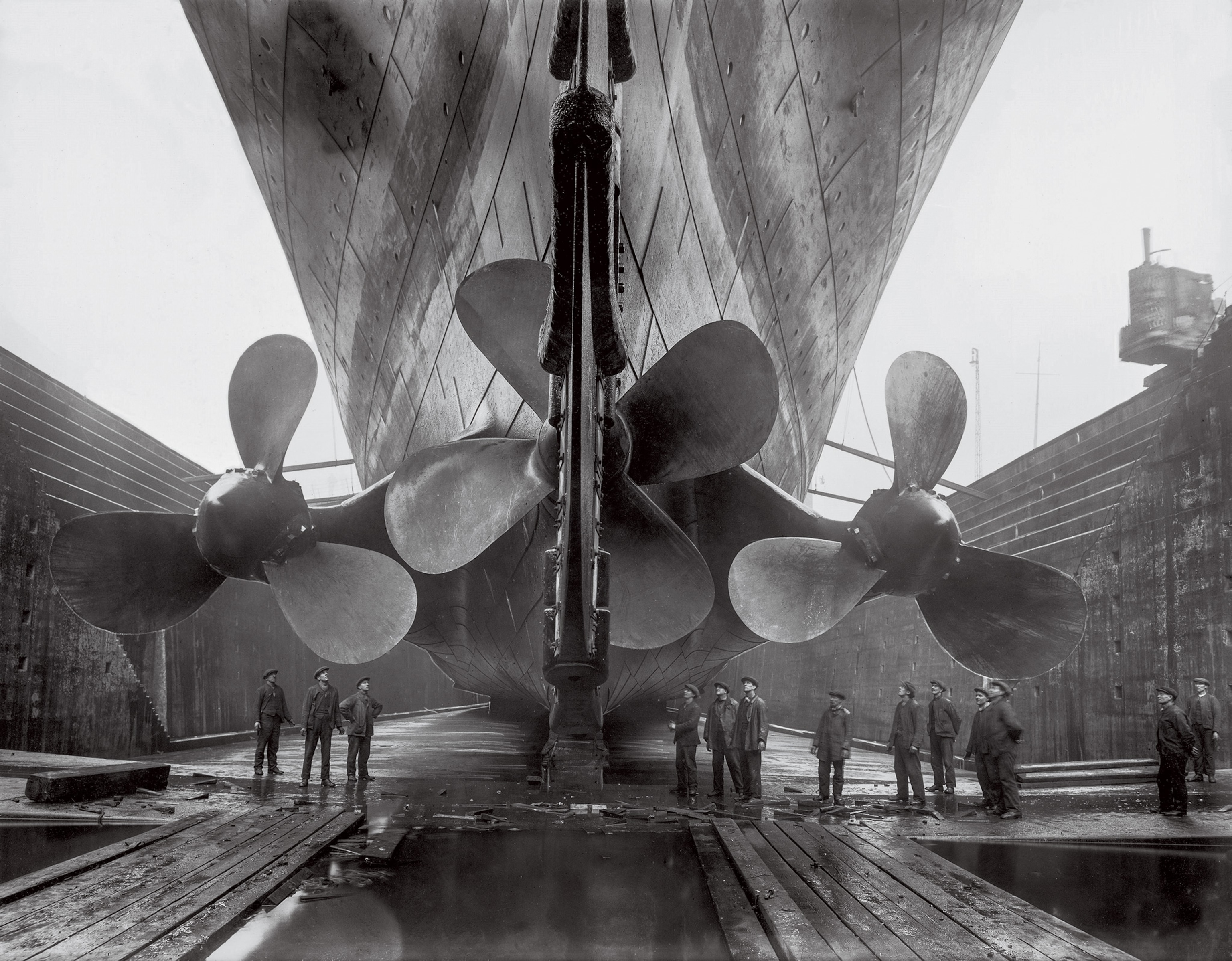 In the Belfast shipyard, workers admire the Titanic’s three 23-foot-wide propellers.
